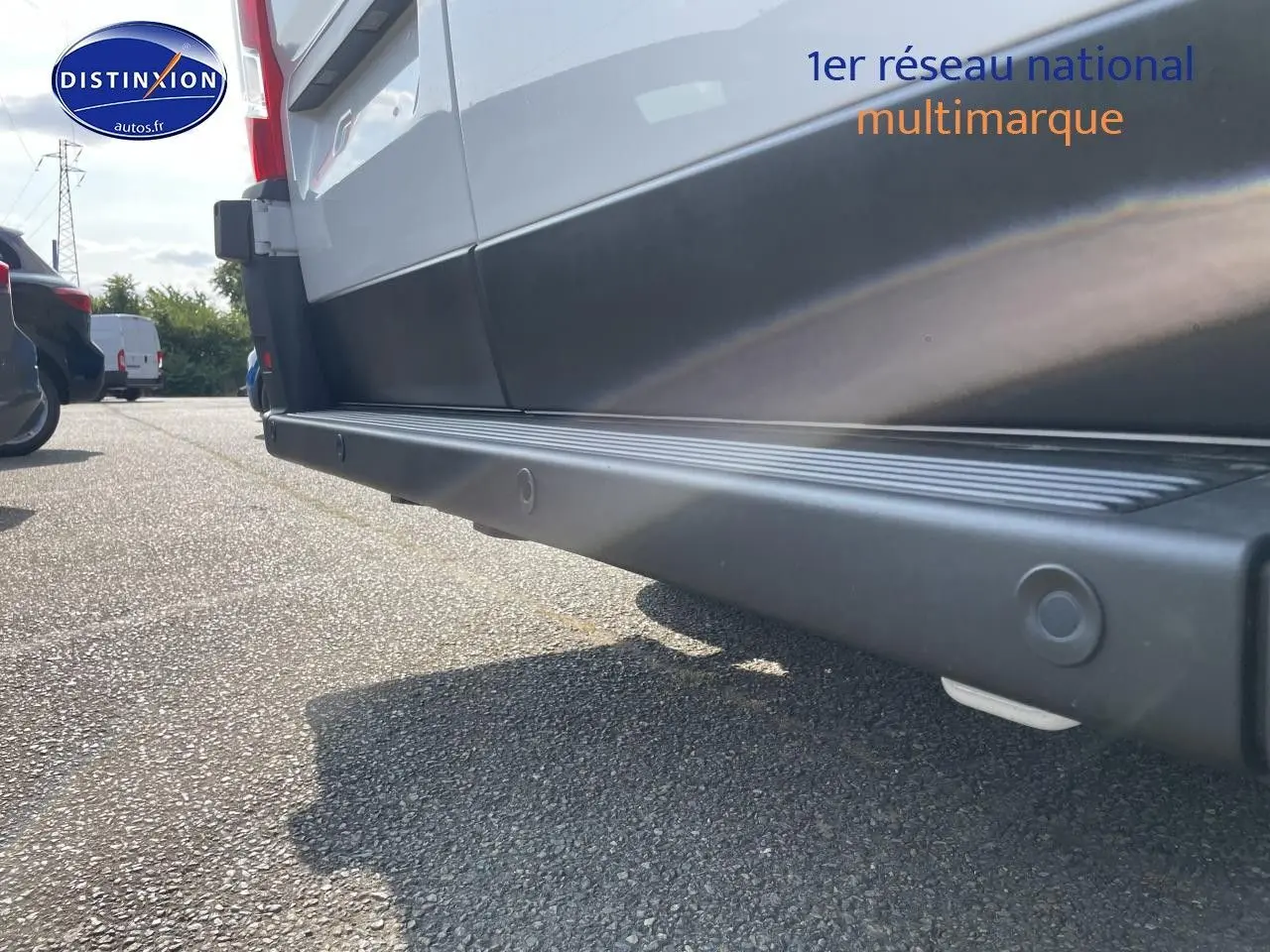 Vue en gros plan du bas côté droit du Peugeot Boxer Fourgon blanc, mettant en valeur la protection latérale noire.