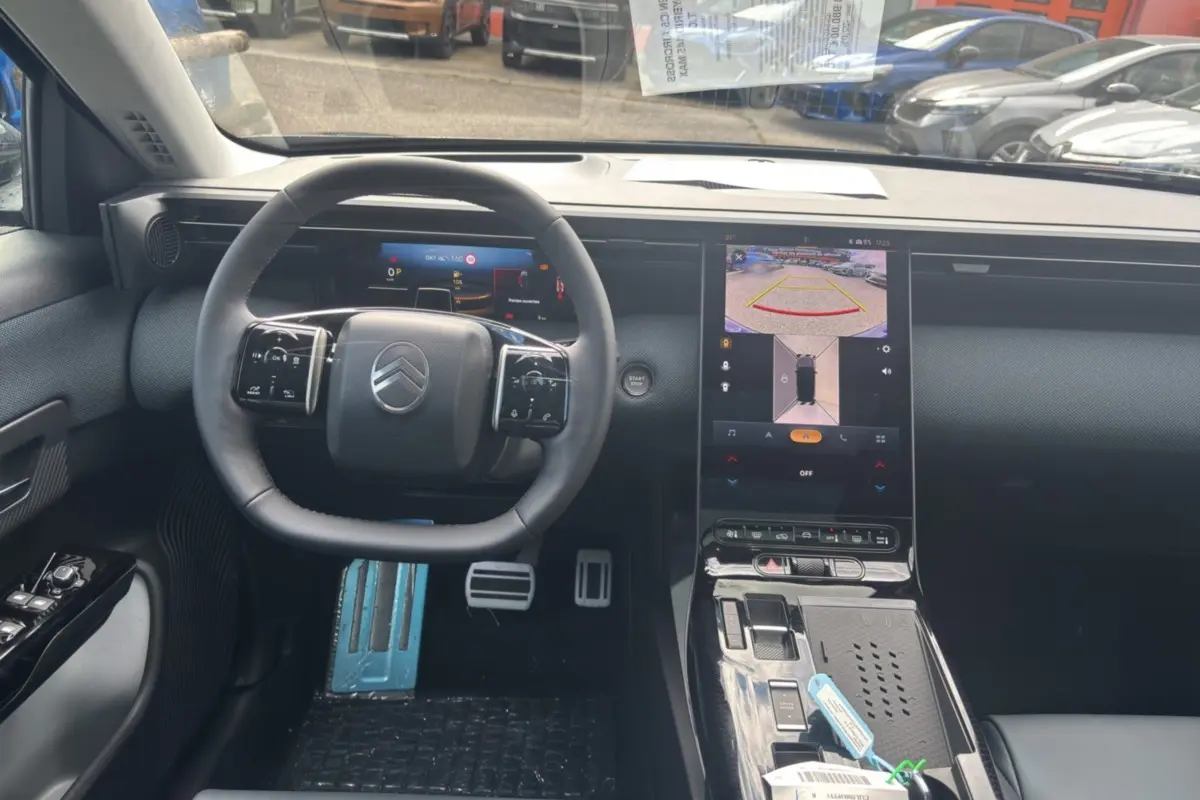 Vue intérieure du poste de conduite du Citroën C5 Aircross New Hybrid 2026, volant cuir multifonctions et écran tactile central allumé.