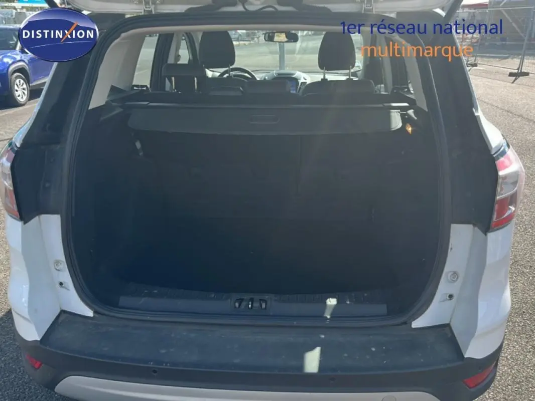 Vue arrière du coffre ouvert d'un Ford Kuga blanc 2019, montrant l'espace de chargement intérieur.