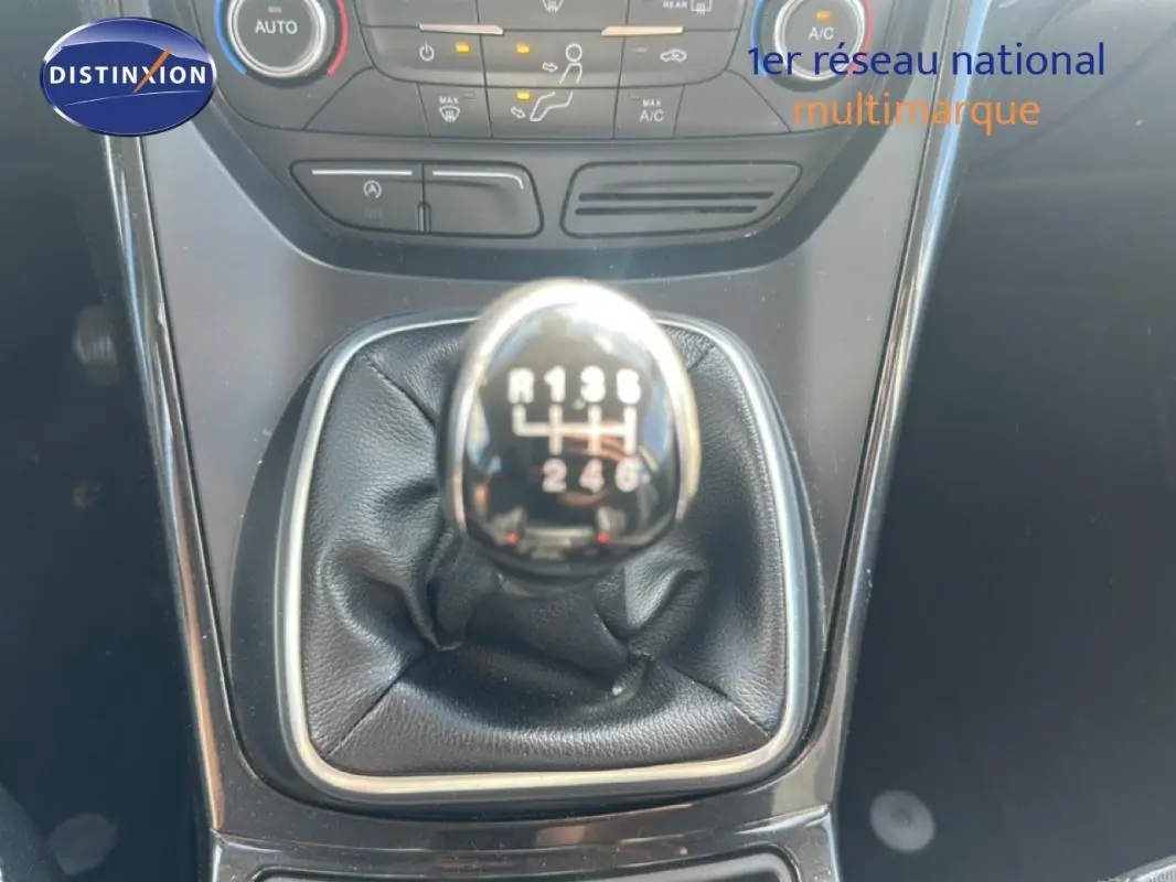 Gros plan sur le levier de vitesses manuel noir du Ford Kuga blanc 2019, avec console centrale et commandes climatisation visibles.
