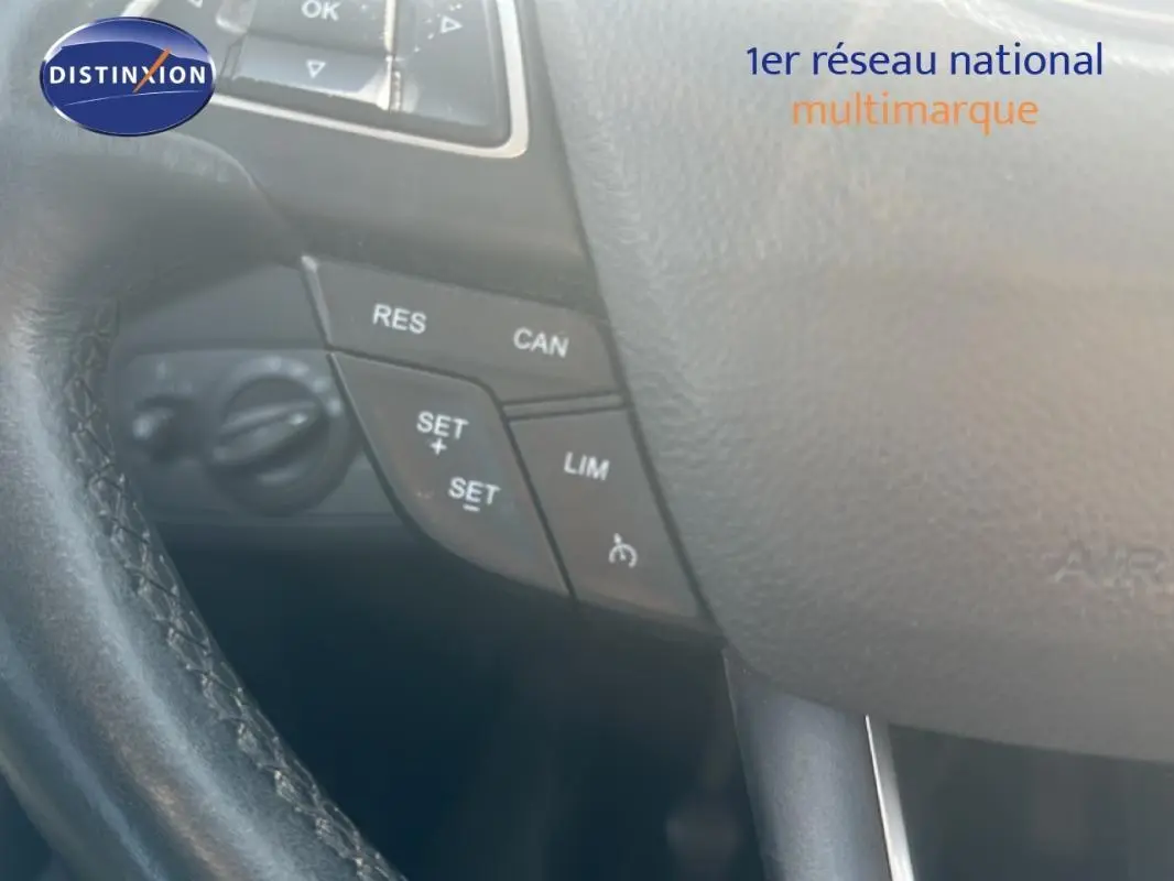 Gros plan sur le volant cuir noir du Ford Kuga 2019, avec commandes de régulateur de vitesse visibles.
