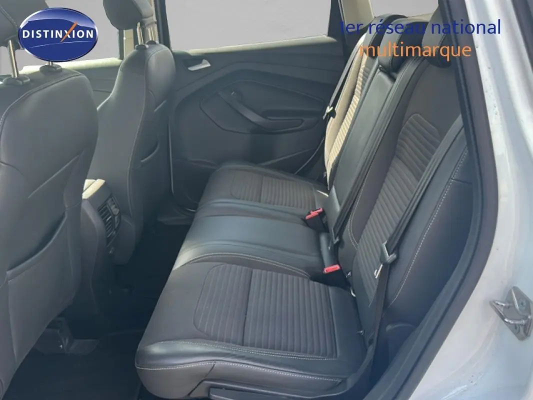 Vue intérieure arrière droite du Ford Kuga blanc 2019, sièges en cuir noir avec surpiqûres blanches.