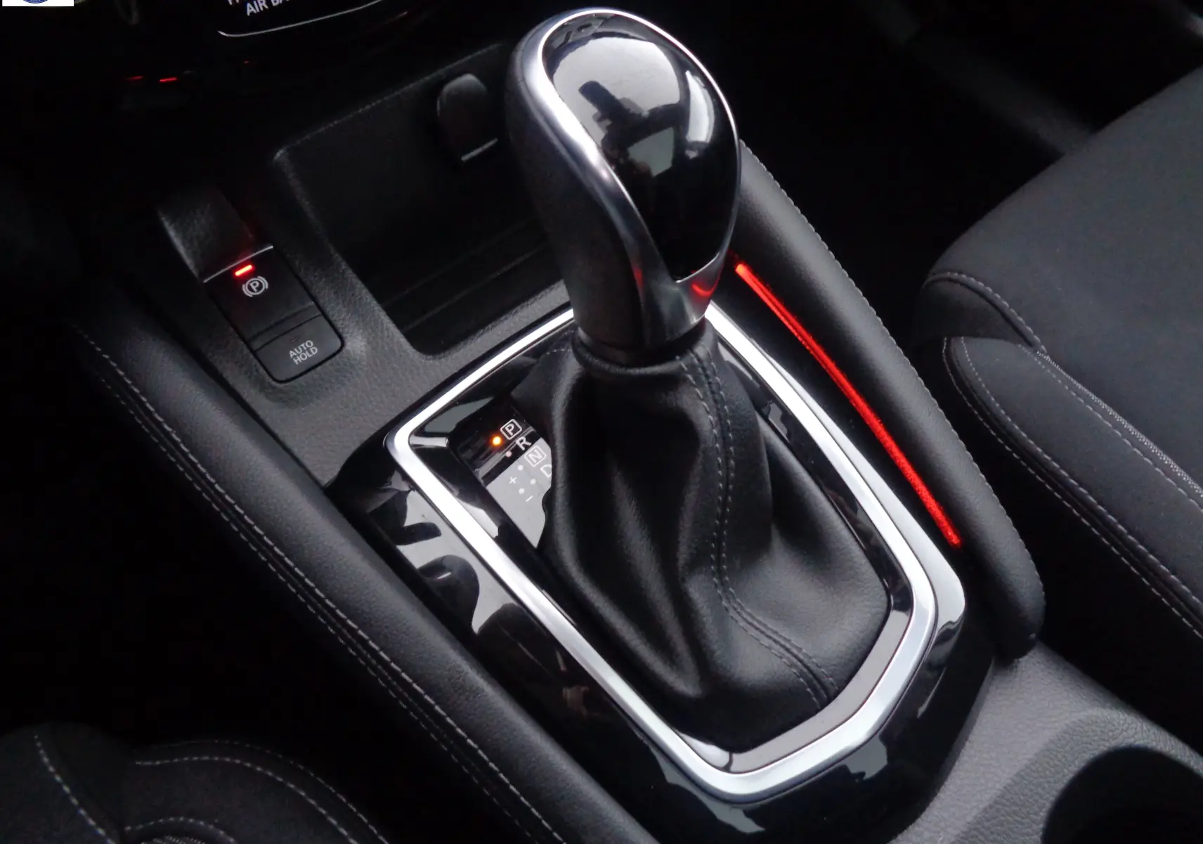 Gros plan sur le levier de vitesses automatique noir et chrome du Nissan Qashqai 2020, intérieur tissu noir.