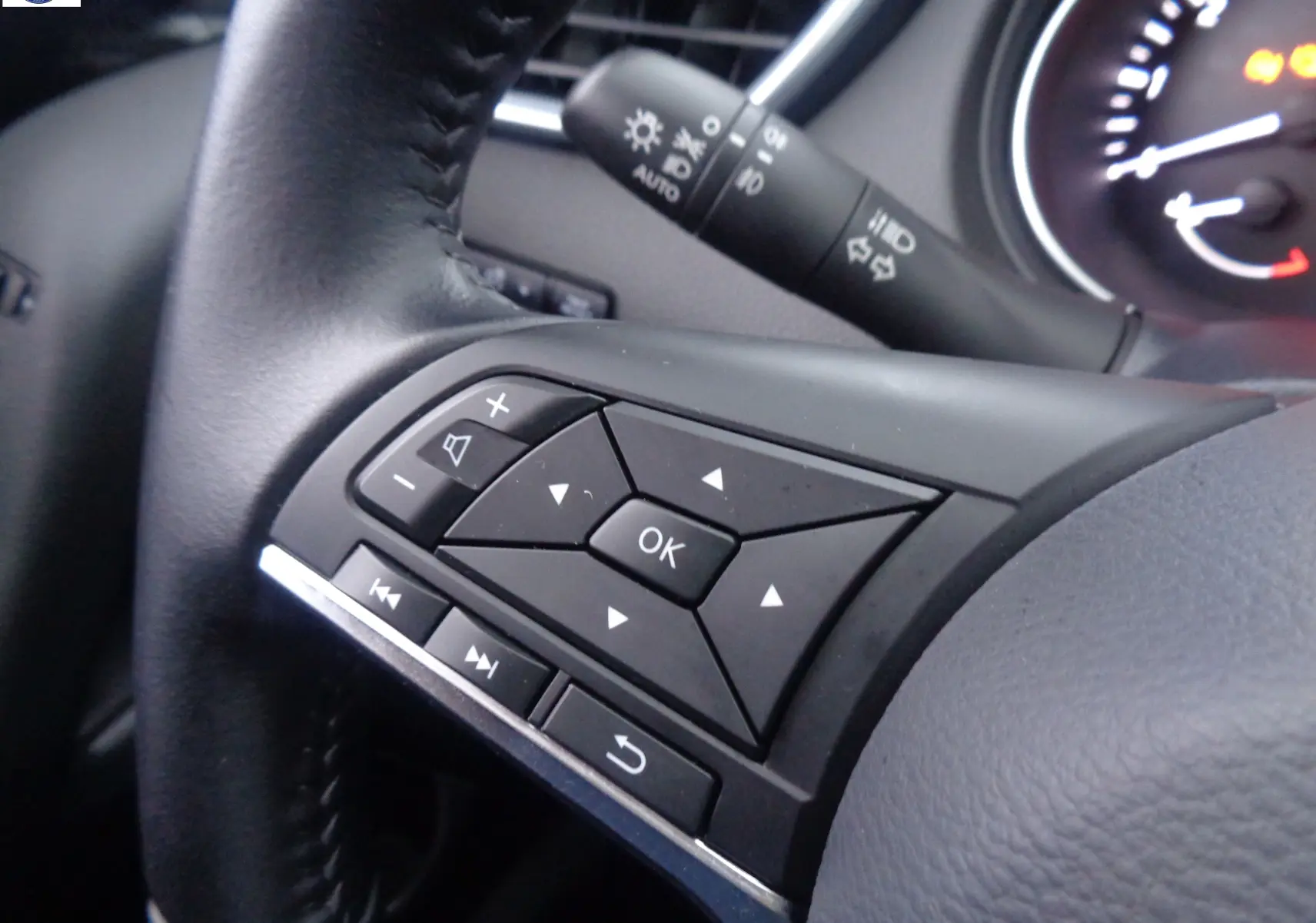 Gros plan sur les commandes multifonctions du volant noir du Nissan Qashqai blanc lunaire 2020.