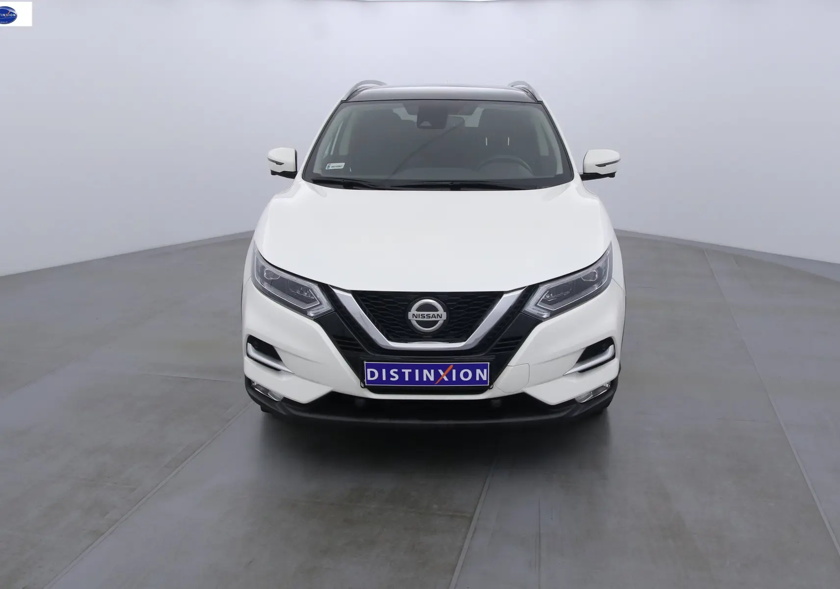 Nissan Qashqai blanc lunaire vu de face, avec calandre noire et phares LED distinctifs.
