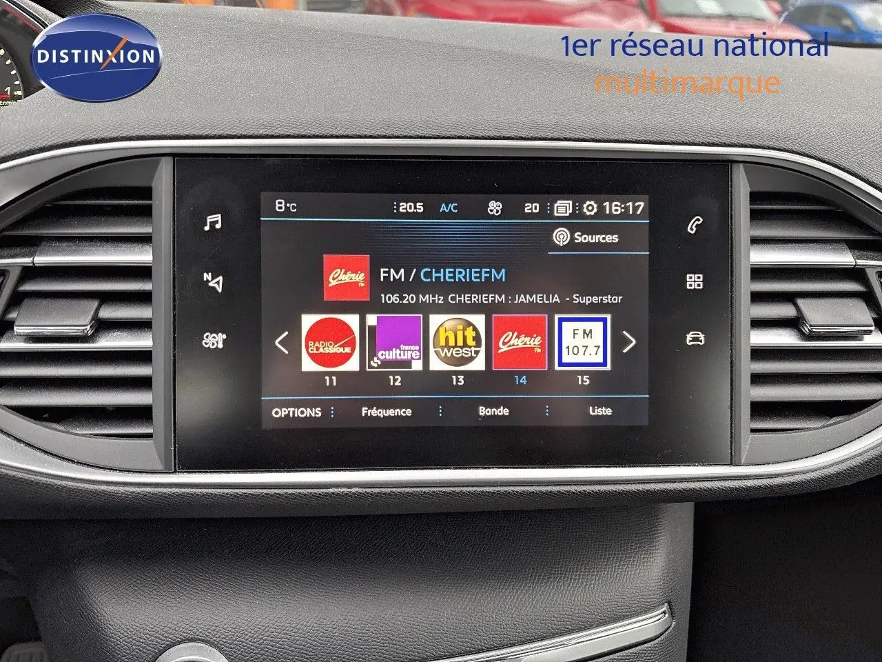 Écran tactile central du tableau de bord de la Peugeot 308 gris Artense, affichant les stations radio FM.