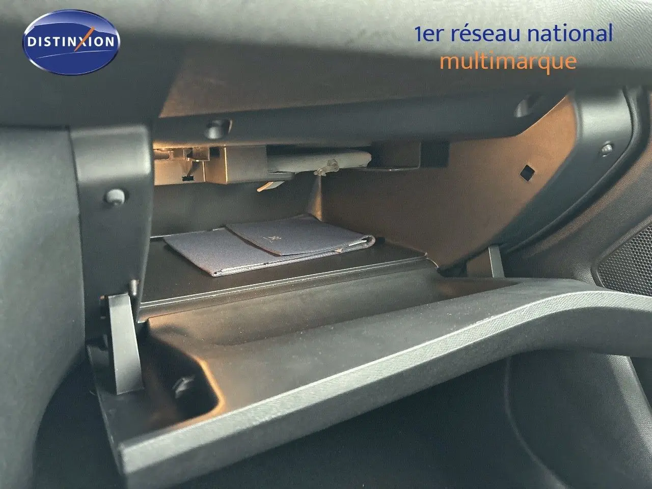 Gant de rangement ouvert côté passager dans une Peugeot 308 gris Artense 2019, montrant un livret à l'intérieur.