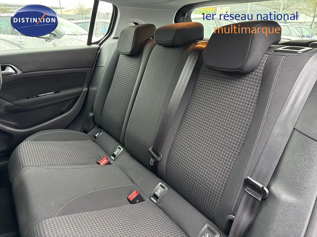 Vue intérieure sur la banquette arrière en tissu noir de la Peugeot 308 gris Artense, avec ceintures et appuie-têtes visibles.