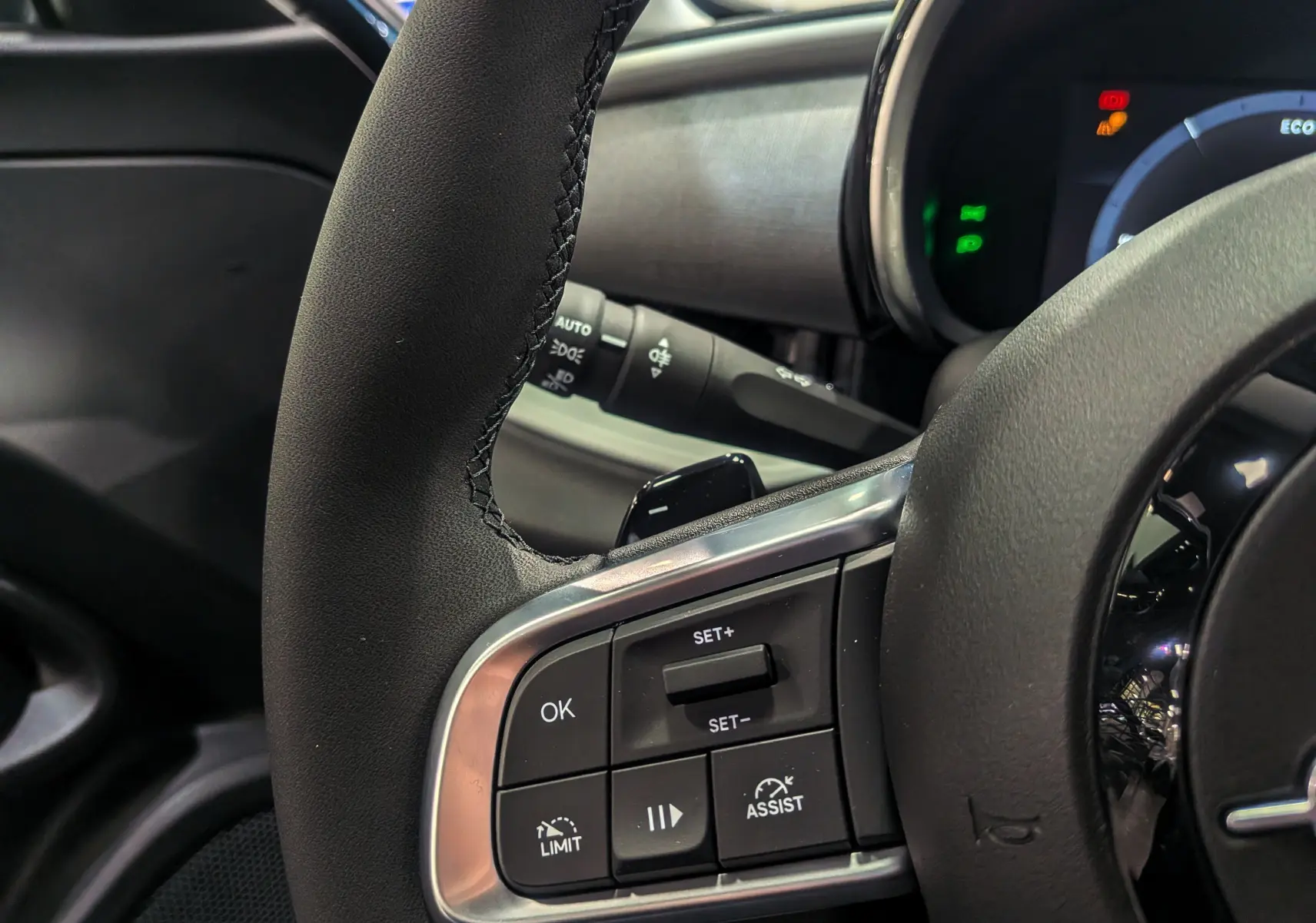 Gros plan sur le volant de la Fiat 600 1.2 Hybrid bleu Sea, montrant les commandes de régulateur et d'assistance.