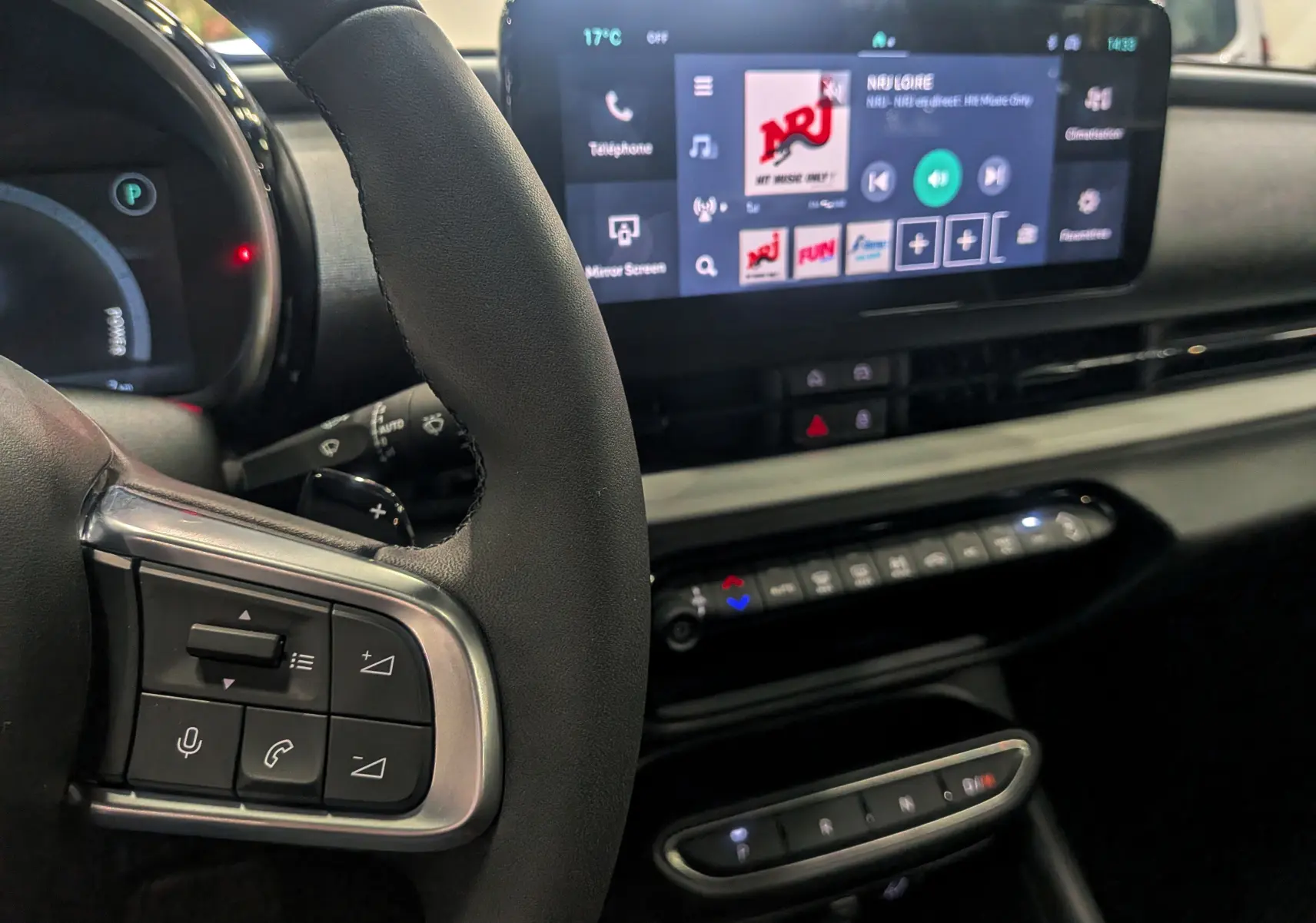 Vue rapprochée du volant et tableau de bord numérique de la FIAT 600 Hybrid 2025 avec écran tactile affichant NRJ.