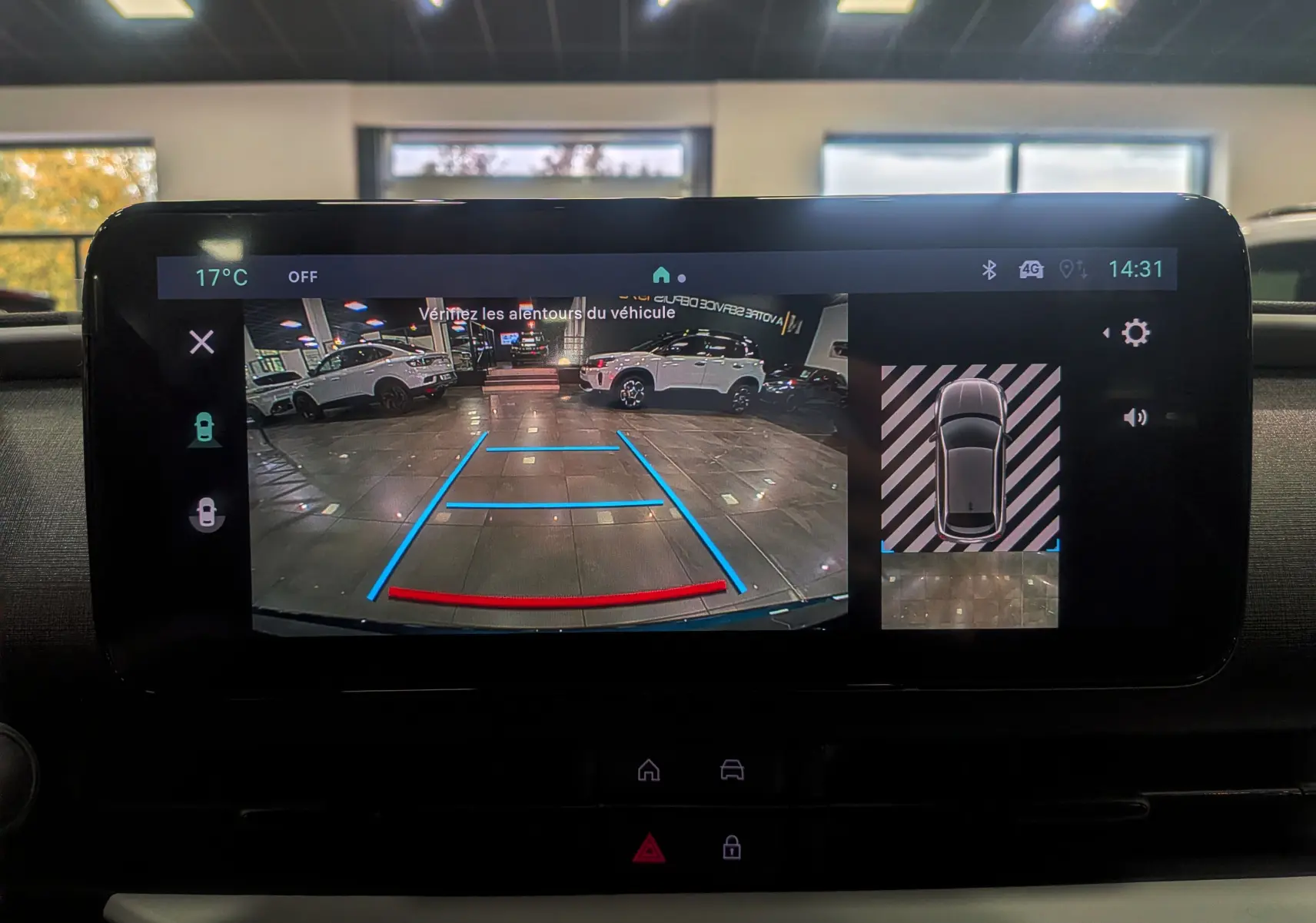 Écran multimédia de la FIAT 600 Hybrid bleu Sea montrant la caméra de recul avec guidage dynamique en intérieur showroom.