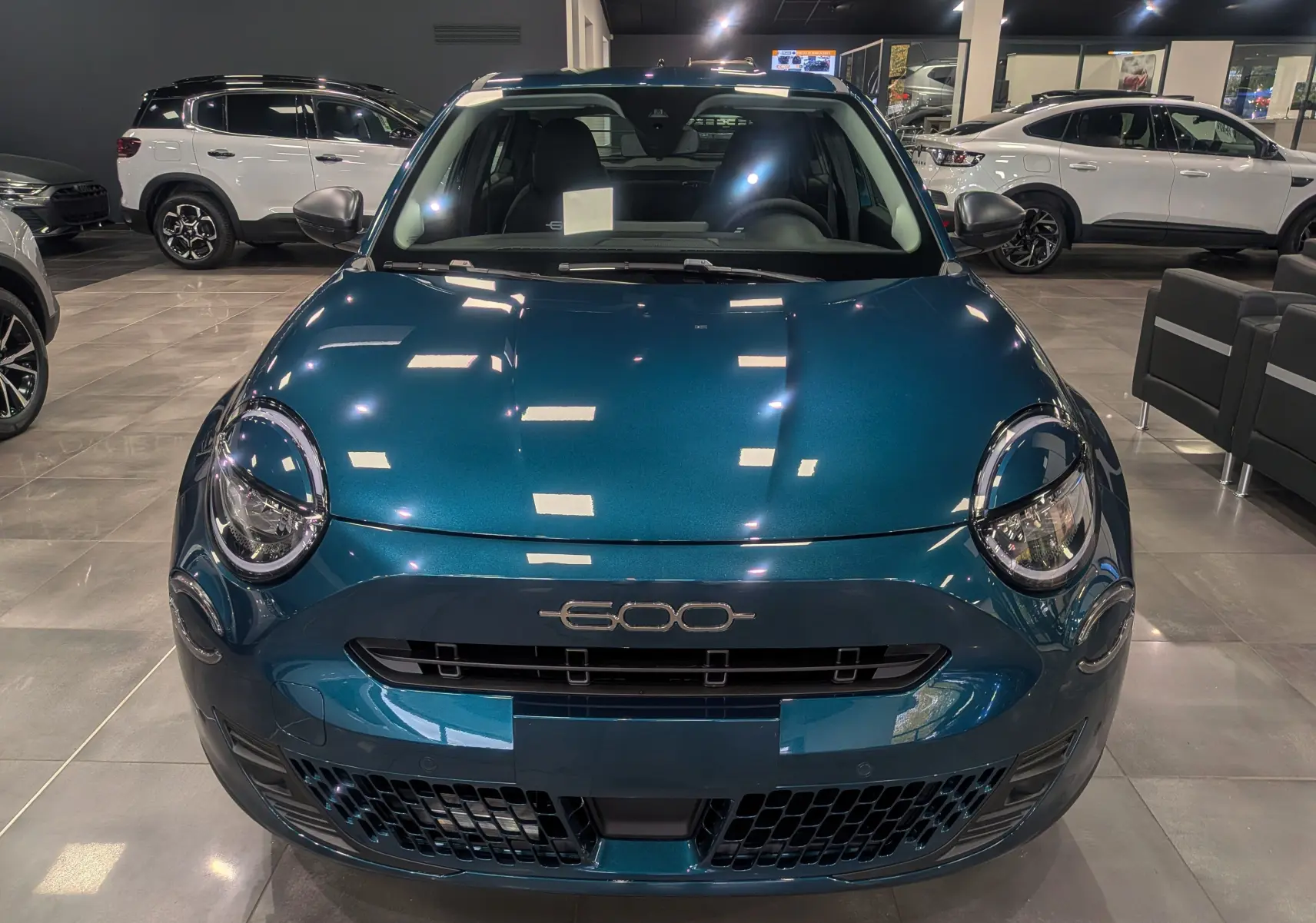 Vue frontale d'une FIAT 600 1.2 Hybrid 145 CH eDCT6 POP en bleu Sea, avec phares ronds et logo distinctif 600.