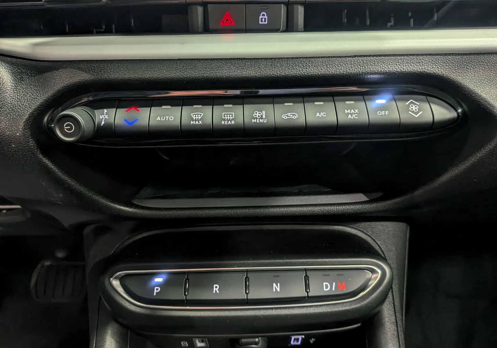 Gros plan sur la console centrale de la Fiat 600 Hybrid 2025 avec commandes climatisation et boîte auto en mode parking.