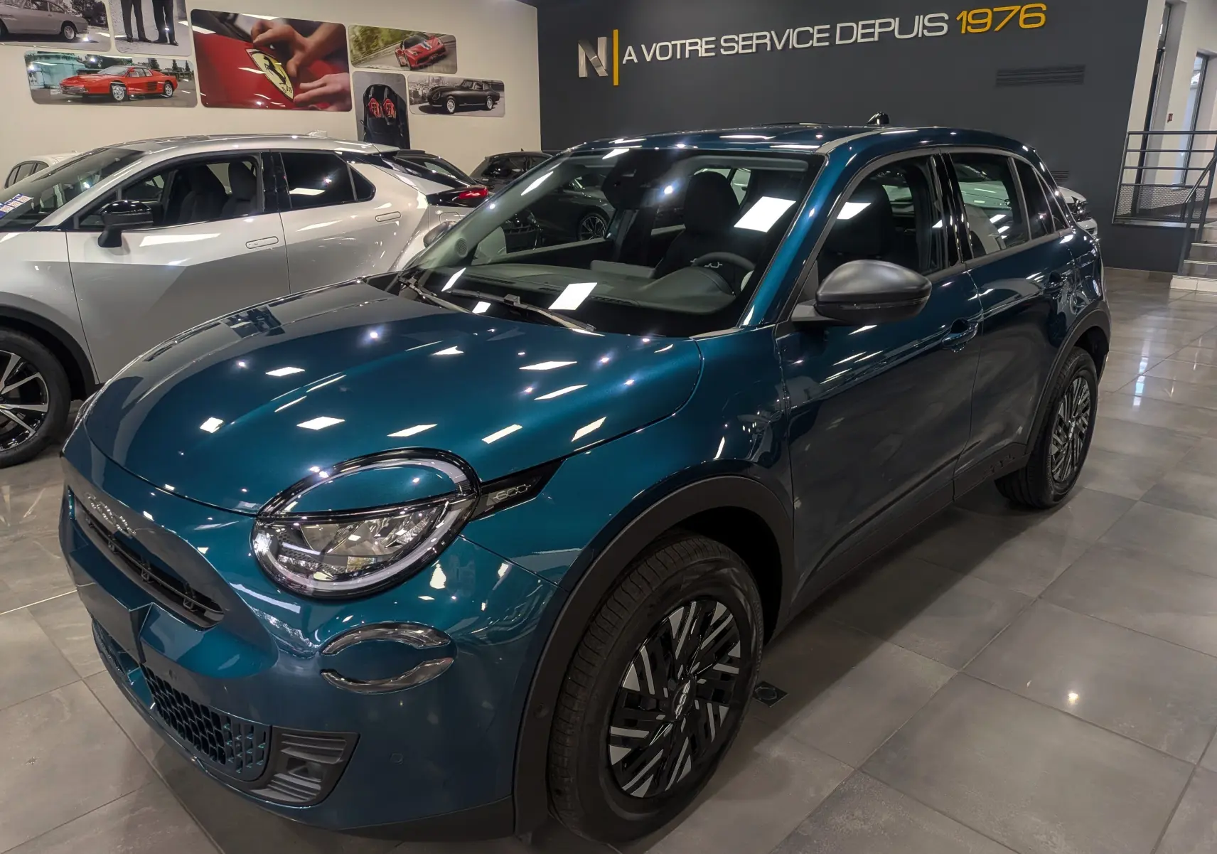 Fiat 600 1.2 Hybrid bleu Sea vue 3/4 avant droit en intérieur, avec jantes noires et détails chromés.