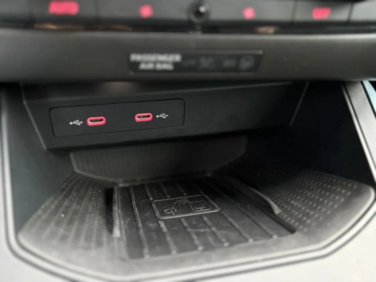 Gros plan sur la console centrale du SEAT Arona 2025, montrant deux ports USB-C rouges et un espace de charge sans fil noir.