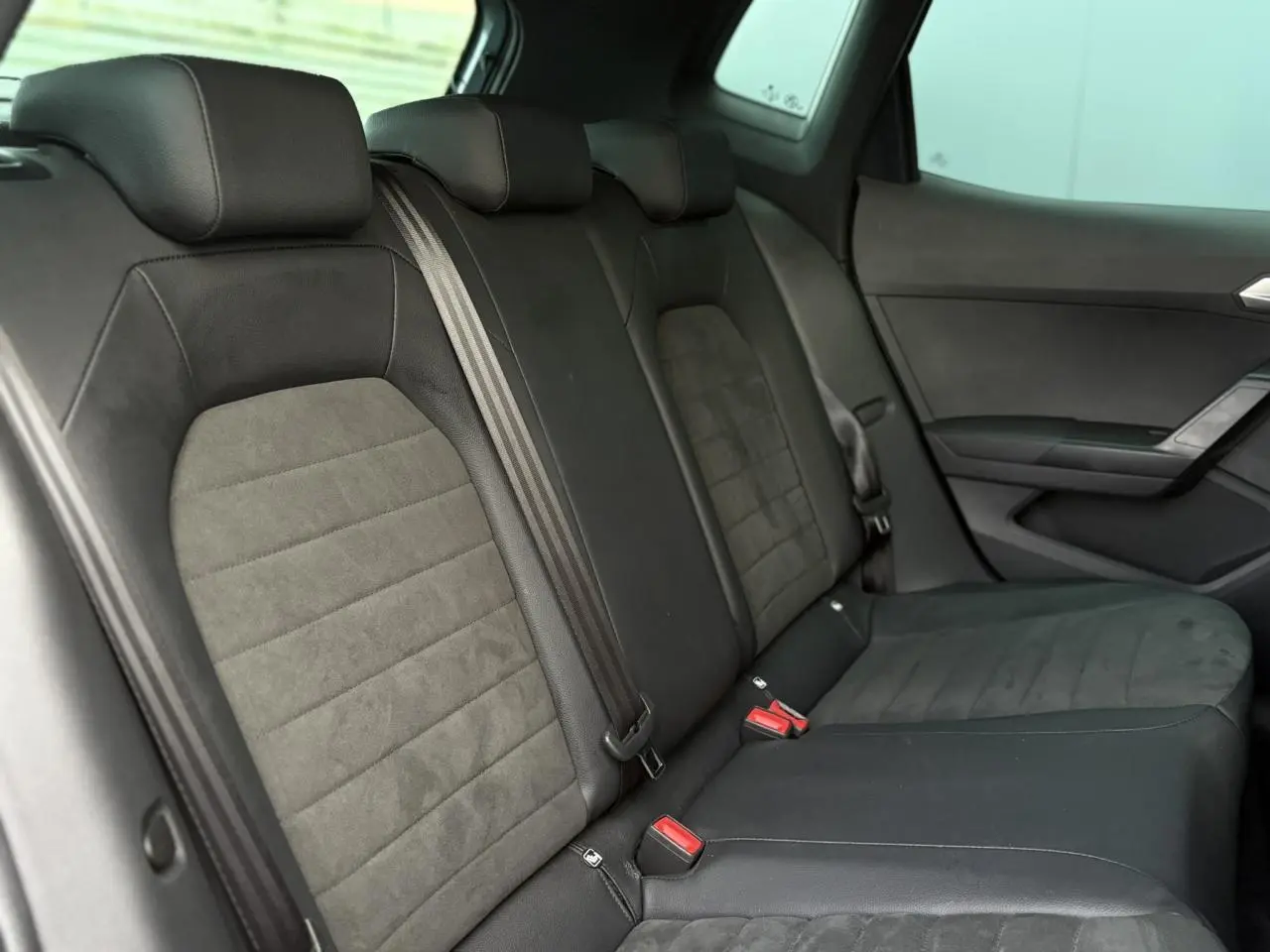 Vue intérieure côté gauche des sièges arrière en tissu noir et gris du SEAT Arona 2025.