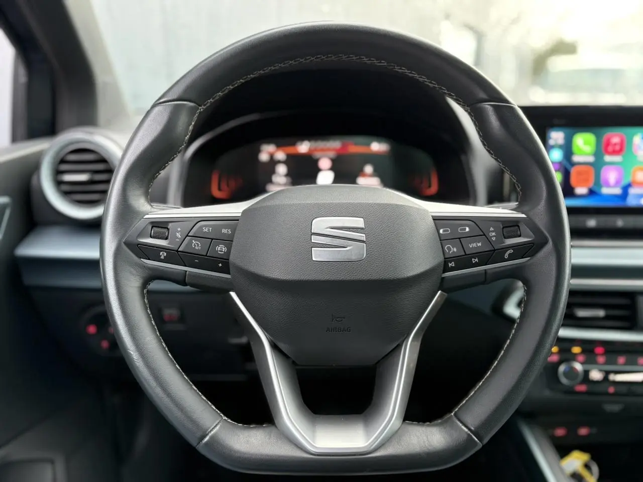 Vue rapprochée du volant cuir noir avec commandes multifonctions du SEAT Arona TSI 115 DSG Xpérience 2025.