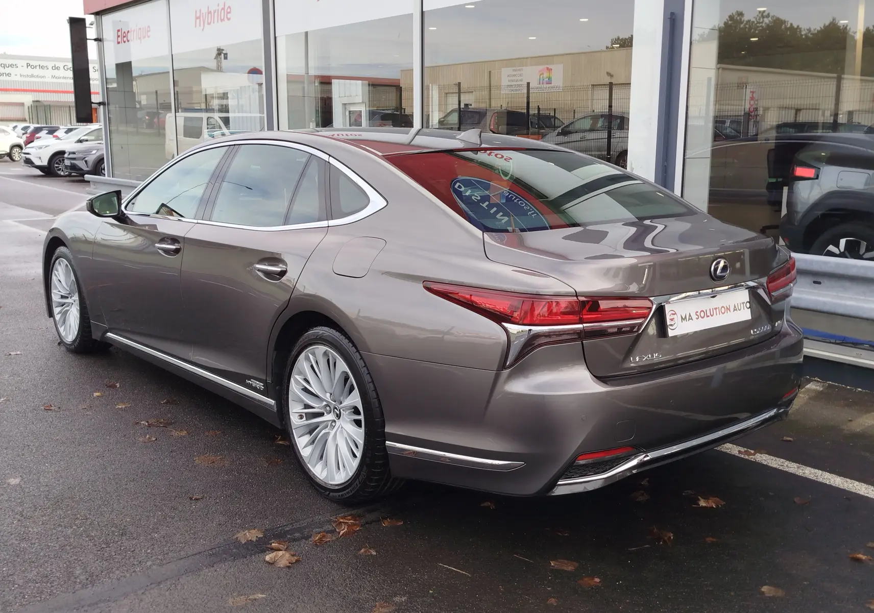 Lexus LS 500H gris manganèse vue 3/4 arrière droit, avec feux arrière LED et jantes alliage multibranches.