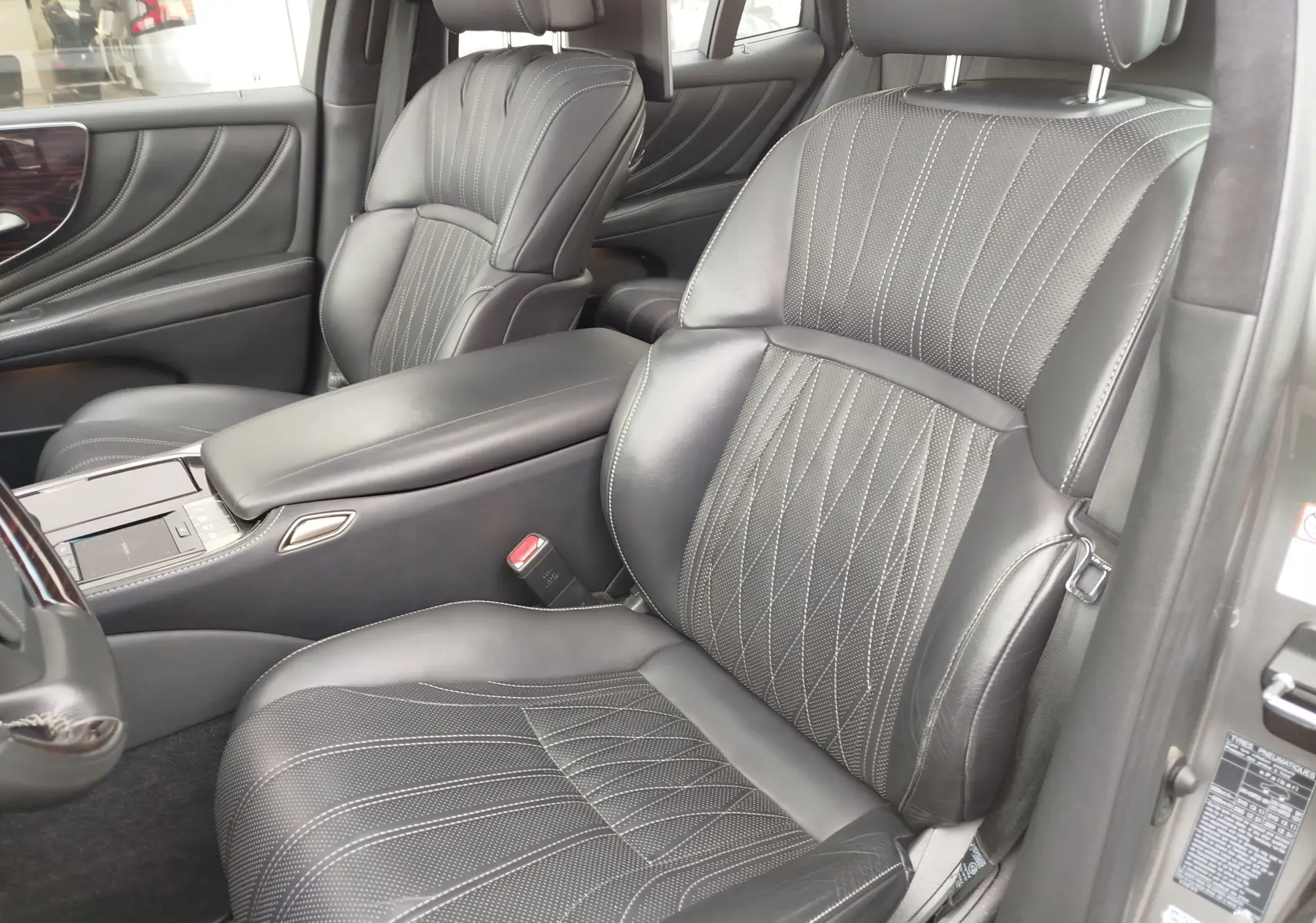 Vue intérieure côté conducteur du Lexus LS 500H 2020, sièges cuir noir avec surpiqûres et console centrale élégante.