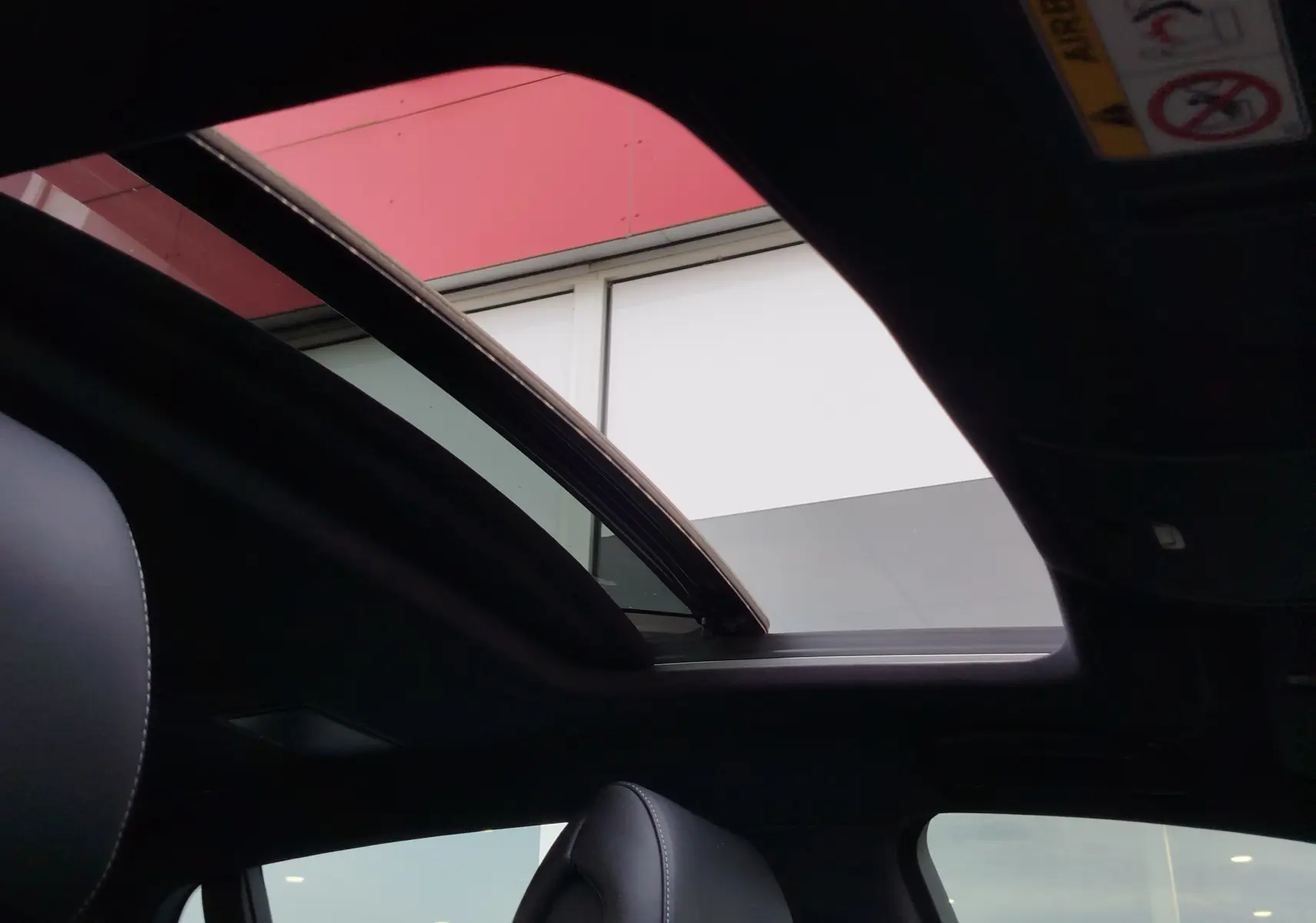 Vue intérieure du toit ouvrant panoramique ouvert sur Lexus LS 500H 2020 gris manganèse avec sièges cuir noir.