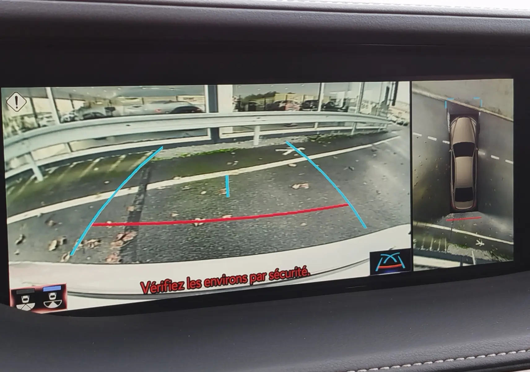 Vue écran caméra de recul et vue aérienne d'une Lexus LS 500H gris manganèse, montrant l'arrière du véhicule en stationnement.