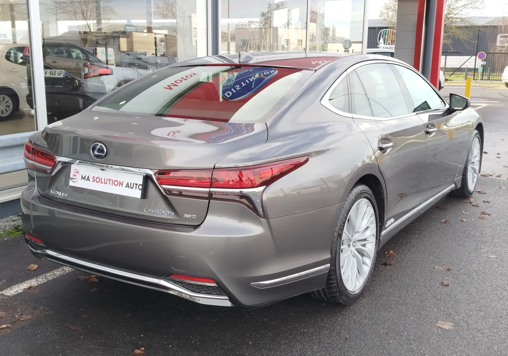 Vue 3/4 arrière droite d'une Lexus LS 500h gris manganèse, soulignant ses feux LED et ses jantes élégantes.