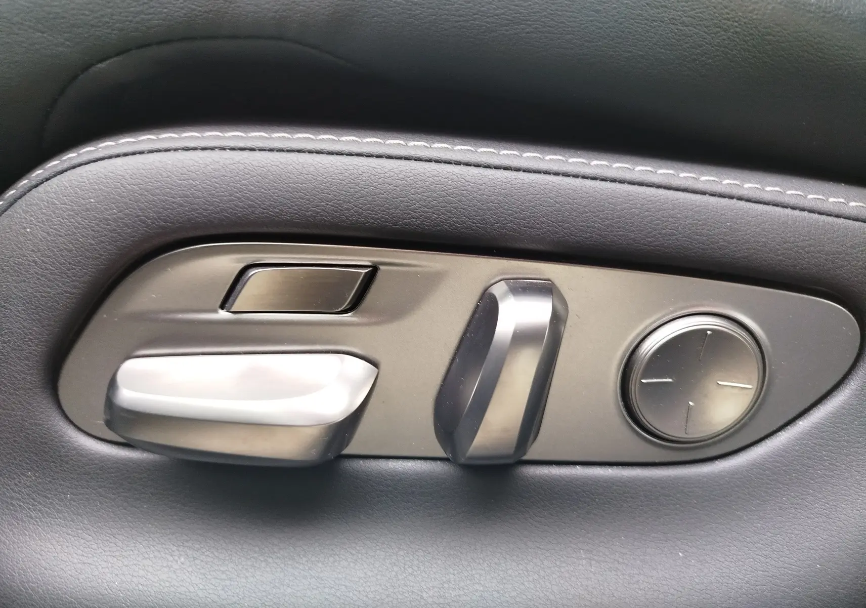 Détail des commandes de réglage électrique du siège en cuir noir de la Lexus LS 500H gris manganèse.