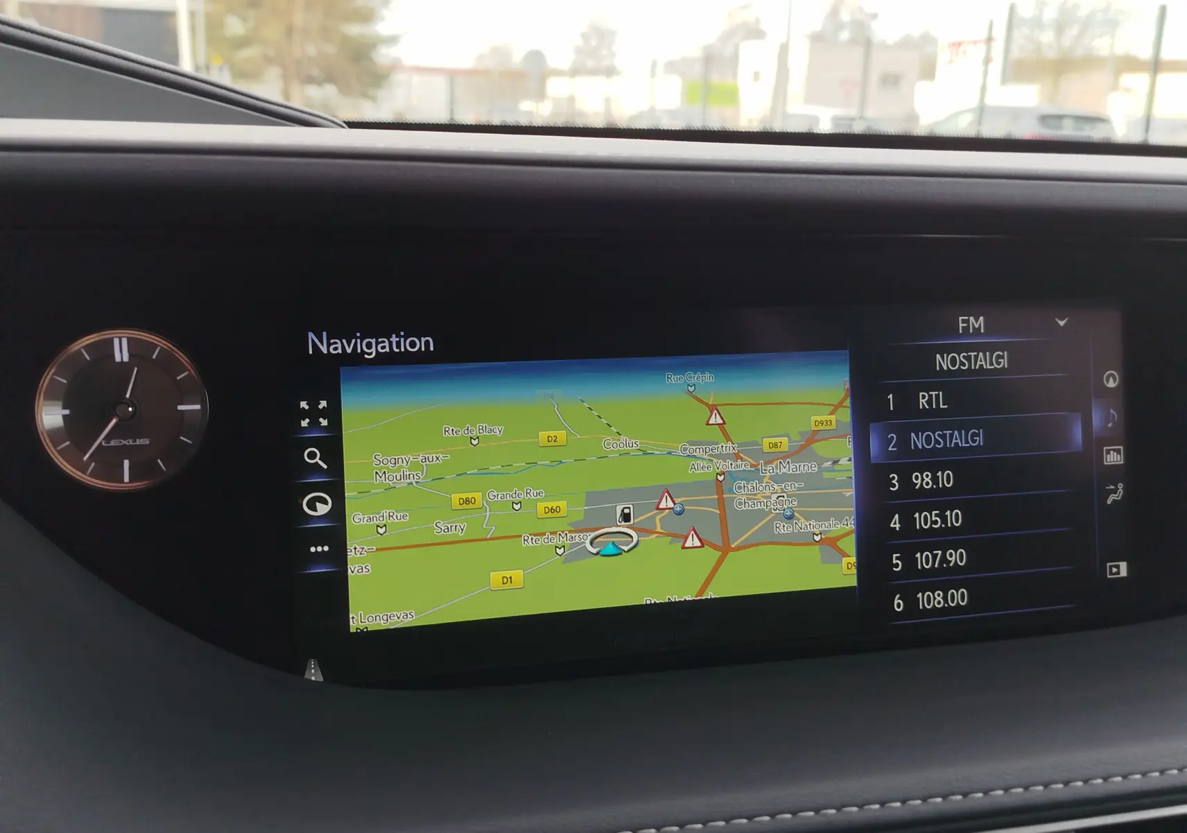 Écran de navigation et radio FM allumé dans l’habitacle d’une Lexus LS 500H, tableau de bord en cuir noir.