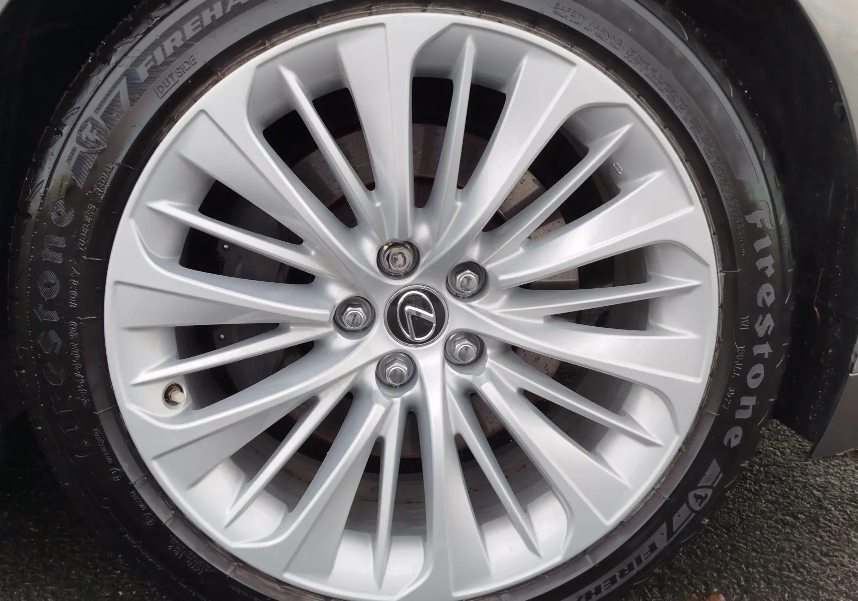 Gros plan sur la jante argentée en alliage du côté avant droit d'une Lexus LS 500H gris manganèse.