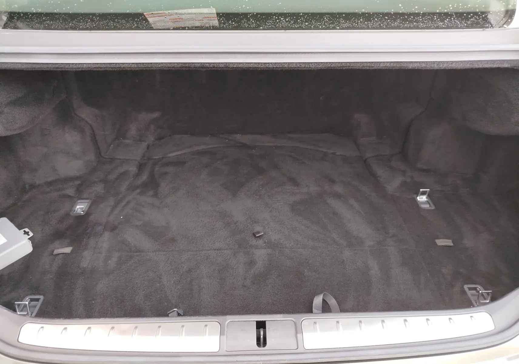 Coffre ouvert de Lexus LS 500H 2020 gris manganèse, vue intérieure montrant un espace de chargement propre et spacieux.