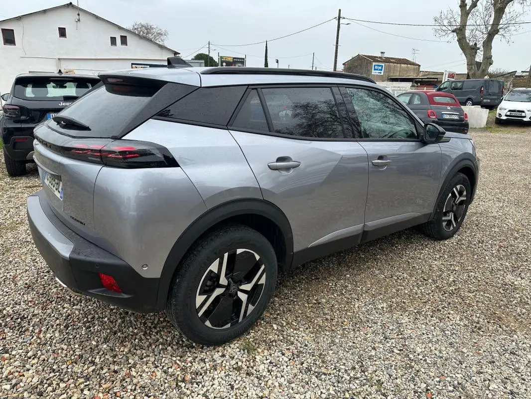 Peugeot 2008 Hybrid gris en vue 3/4 arrière droit, avec jantes alliage noires et toit noir contrasté.