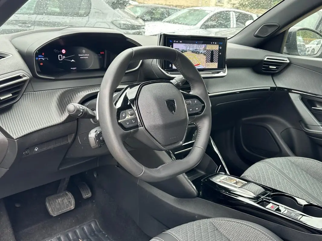 Vue intérieure côté conducteur du Peugeot 2008 Hybrid 145 e-DCS6 Allure 2025, avec tableau de bord numérique et écran tactile.