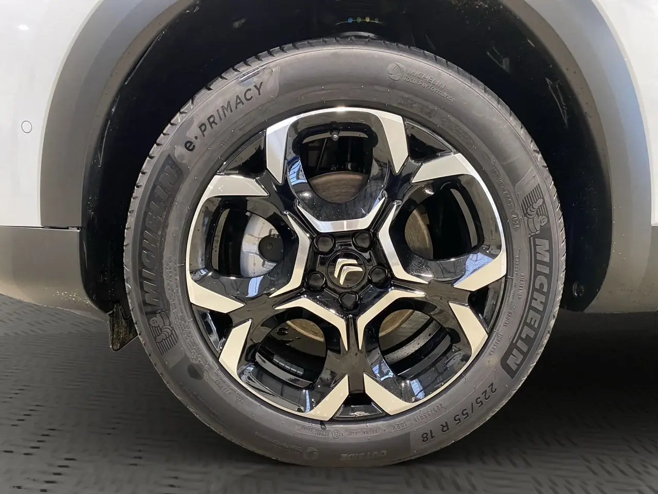 Gros plan sur la roue arrière droite d'un Citroën C5 Aircross blanc avec jante noire et pneus Michelin.