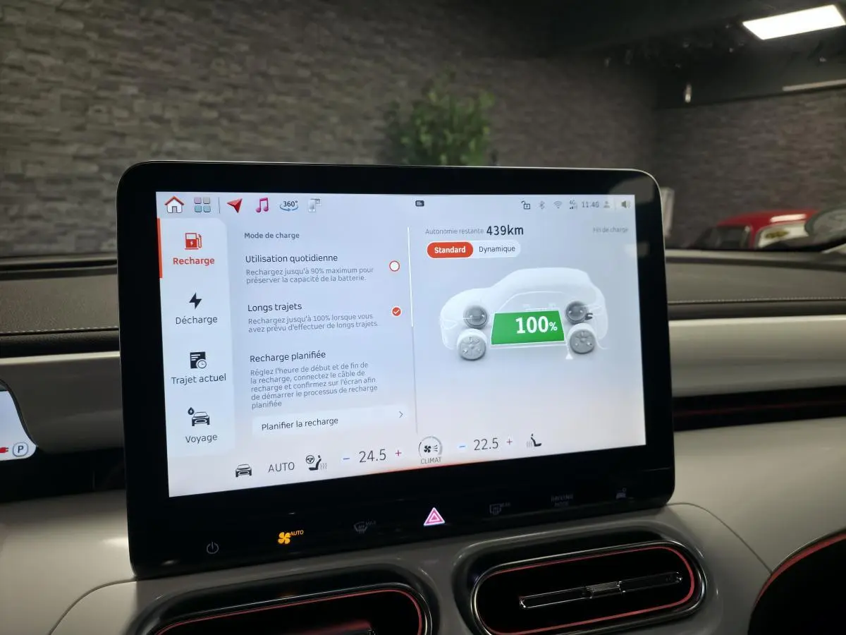 Écran tactile central affichant la recharge à 100% dans l'habitacle clair d'une Smart #1 blanche 2024 électrique