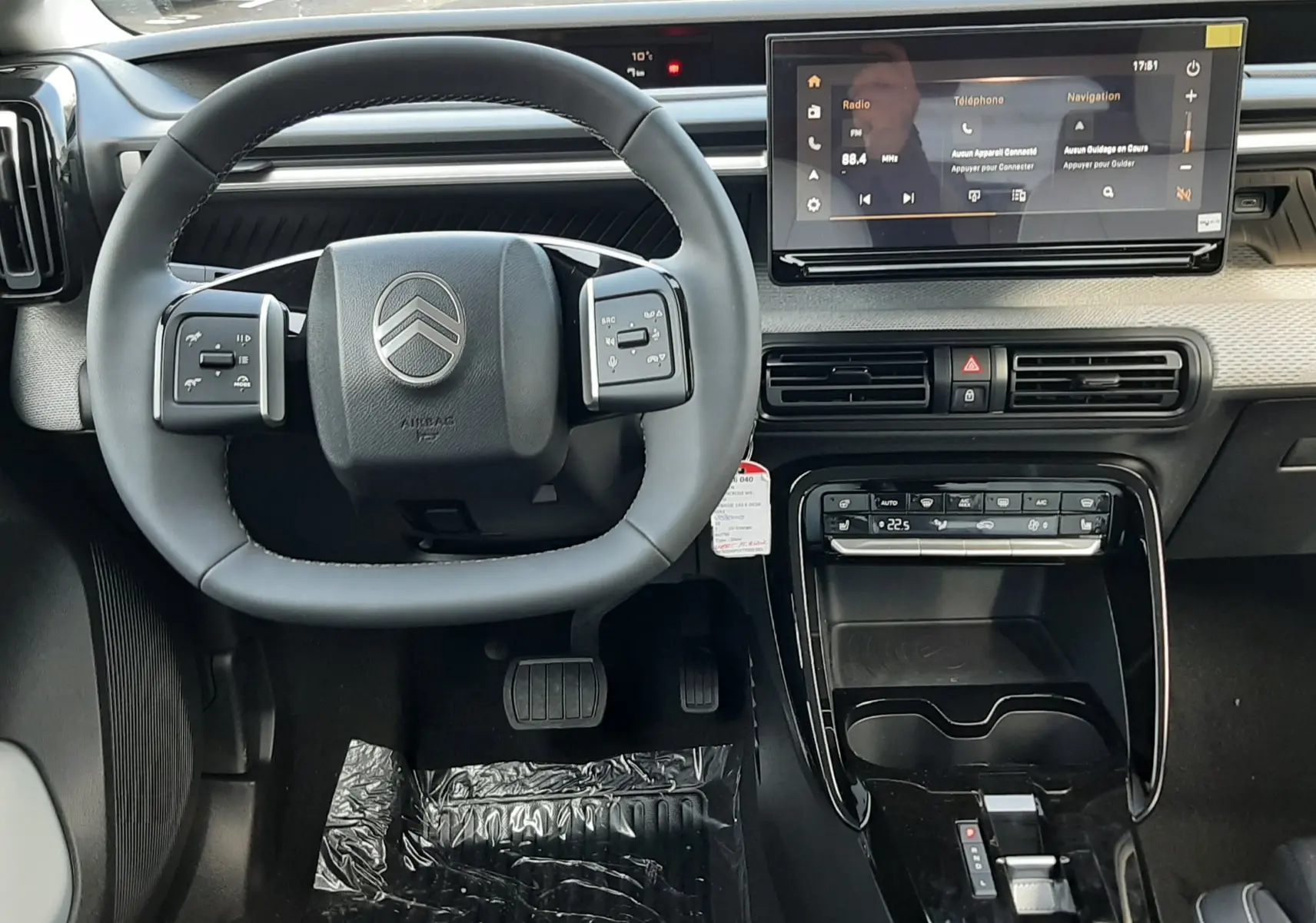 Vue intérieure frontale du tableau de bord et volant noir du Citroën C3 Aircross hybride 2026 avec écran tactile et console centrale brillante.