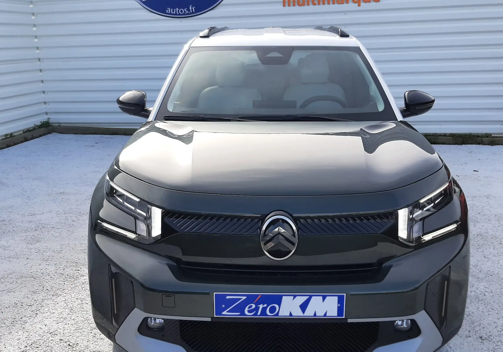 Vue avant centrée du Citroën C3 Aircross hybride 2026 en vert Montana avec toit blanc opale et calandre noire distinctive.