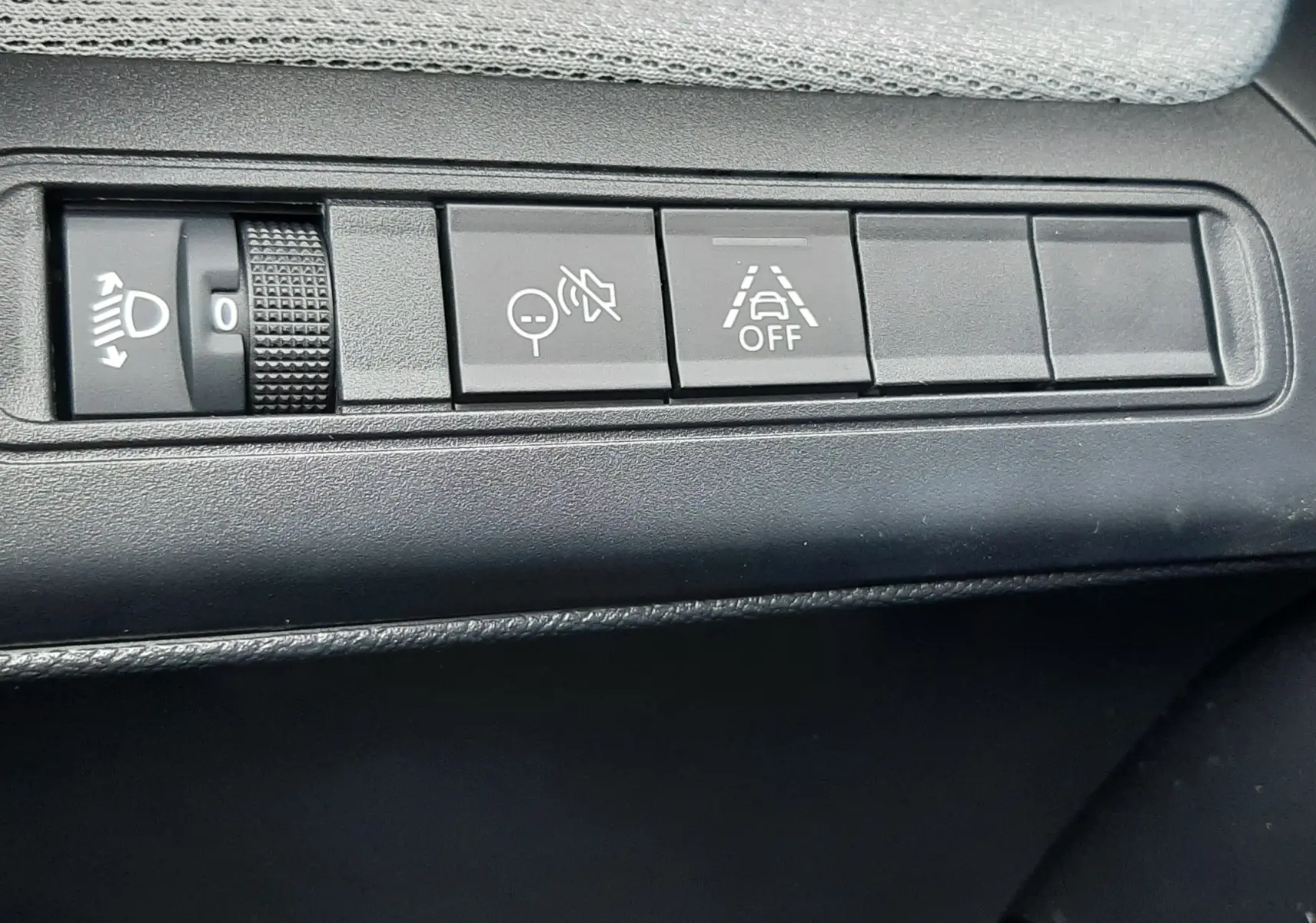 Gros plan sur les boutons de commande noirs du tableau de bord intérieur du Citroën C3 Aircross hybride 2026.