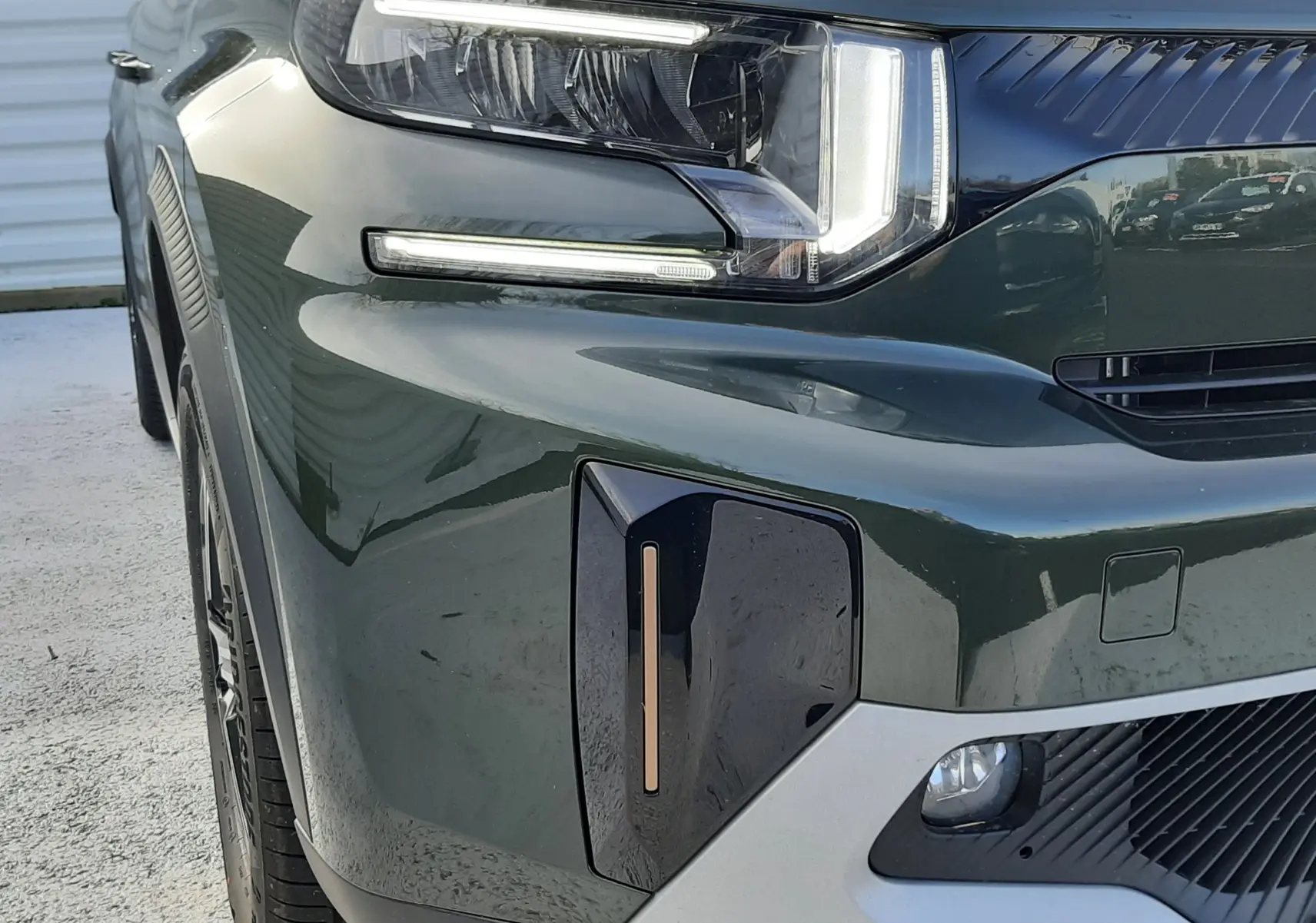 Gros plan sur l’avant gauche du Citroën C3 Aircross hybride 2026 vert Montana avec éclairage LED et détails noirs contrastants.