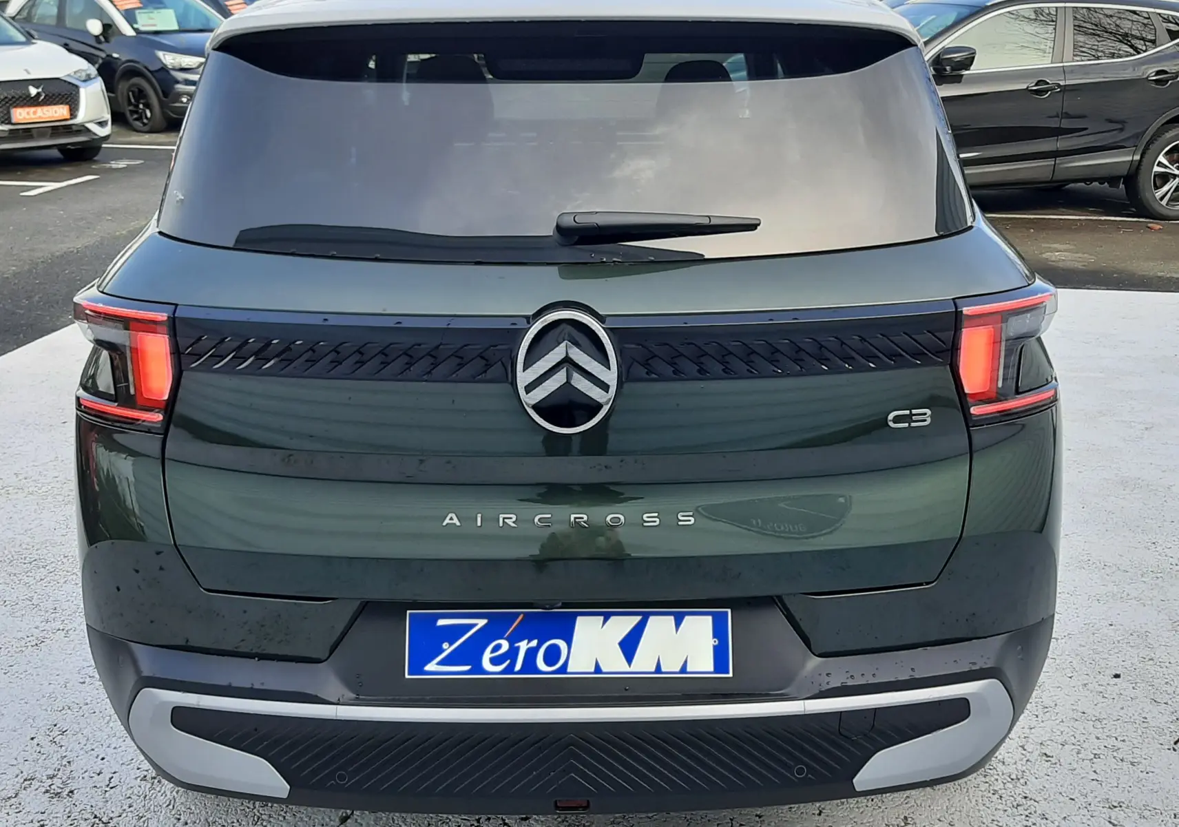 Vue arrière d'un Citroën C3 Aircross hybride 2026 vert Montana avec toit blanc opale, feux arrière LED et logo central.
