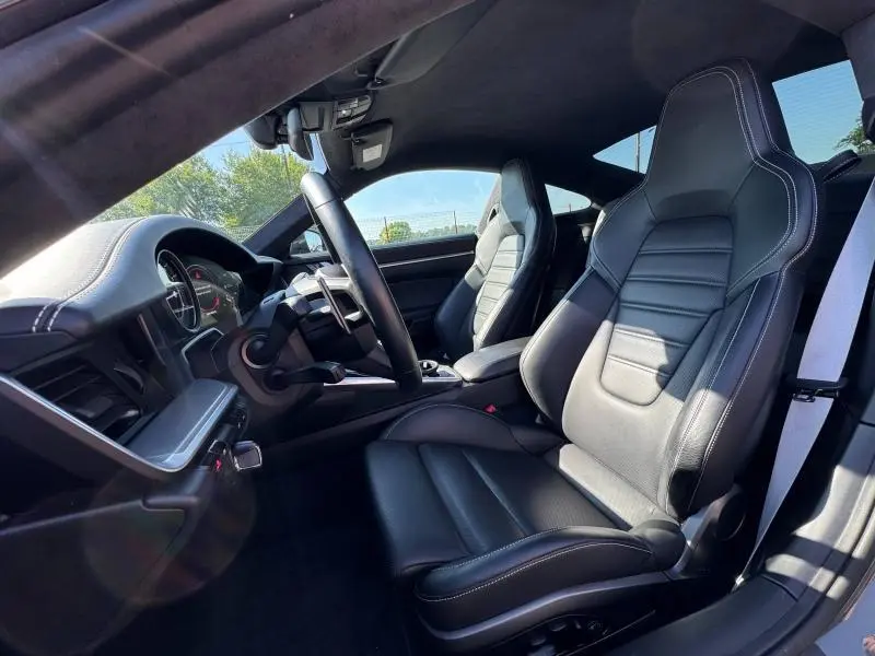 Intérieur noir de la Porsche 911 Turbo S 2020 vu côté conducteur, sièges sport en cuir avec surpiqûres blanches.