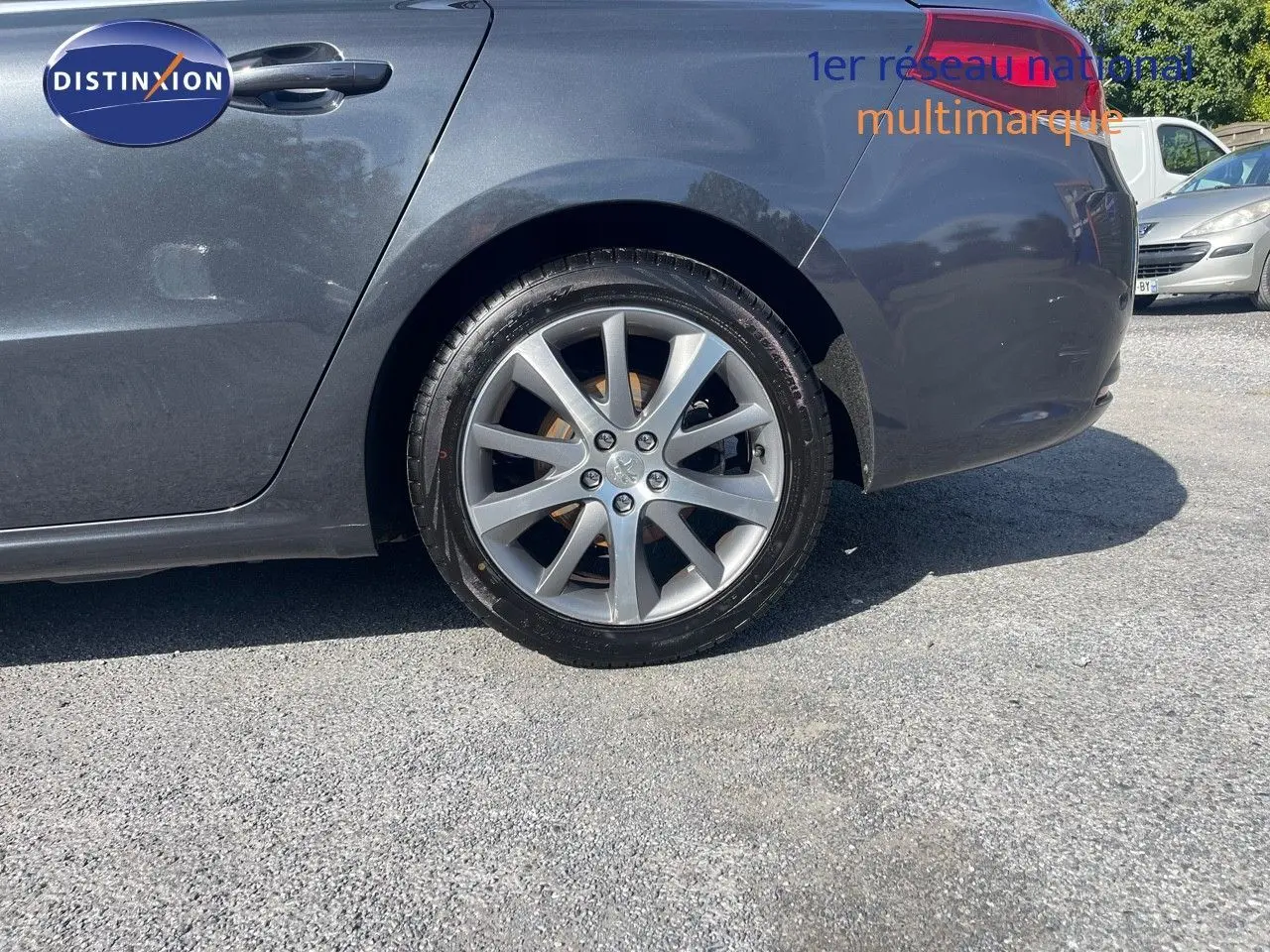 Gros plan sur la roue arrière droite d'une Peugeot 508 noire 2026, version 2.0 BlueHDi GT Line, sur un sol goudronné.