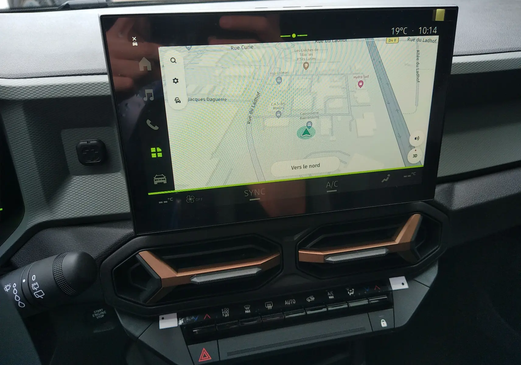 Écran tactile central avec navigation GPS et aérateurs hexagonaux cuivrés dans le tableau de bord du Dacia Bigster 2025.