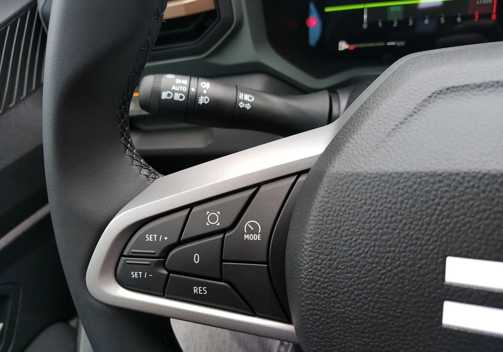 Gros plan sur le volant du Dacia Bigster gris schiste 2025, montrant les commandes de régulateur de vitesse à gauche.