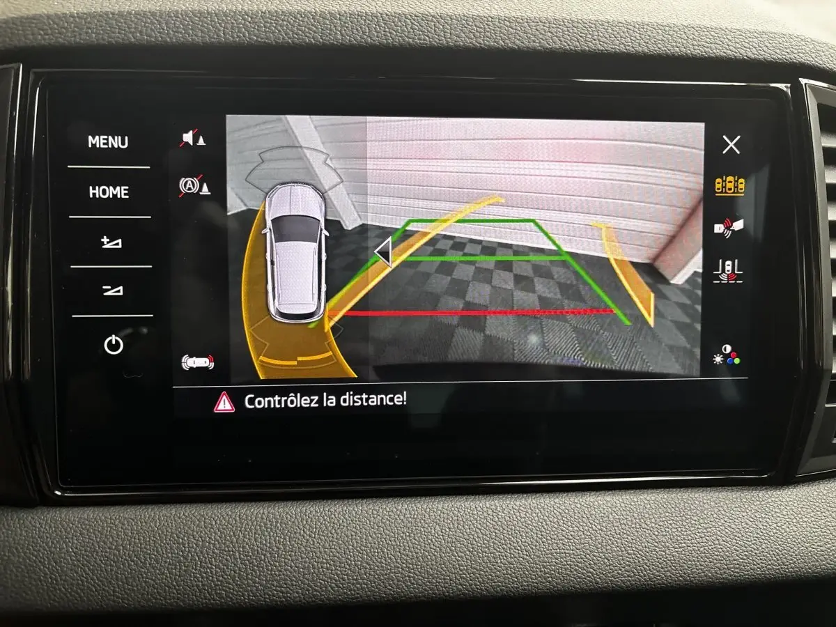 Écran tactile central montrant la caméra de recul avec guidage dynamique sur Skoda Karoq noir, vue intérieure du tableau de bord.