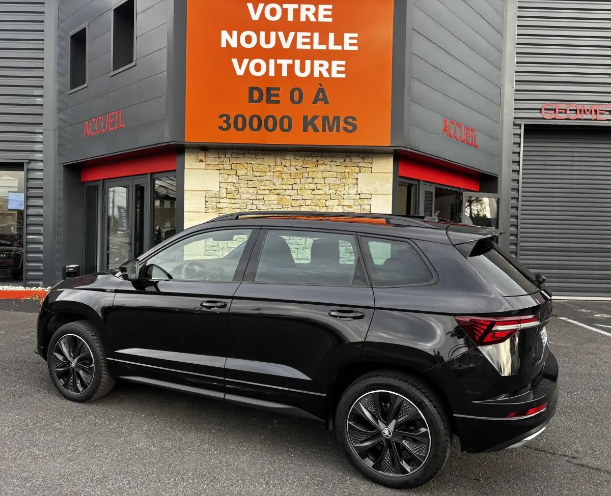 Vue latérale droite d'un SKODA KAROQ noir 2025 avec jantes alliage et feux arrière LED distinctifs.