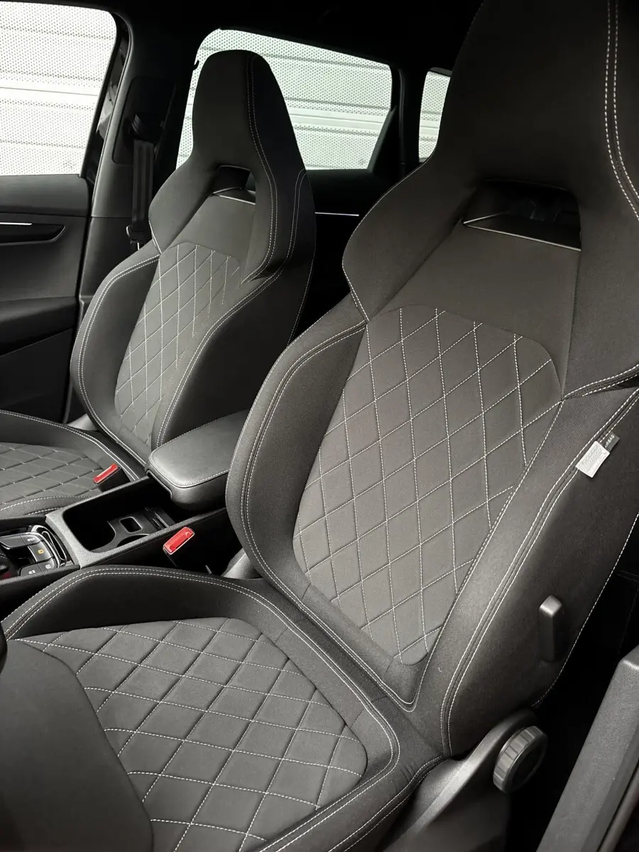Gros plan sur les sièges avant noirs au tissu matelassé du Skoda Karoq 2025 version Sportline.