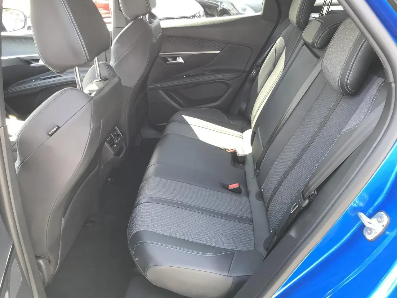 Vue intérieure côté droit sur la banquette arrière en tissu et cuir du Peugeot 3008 Bleu Iron 2022.