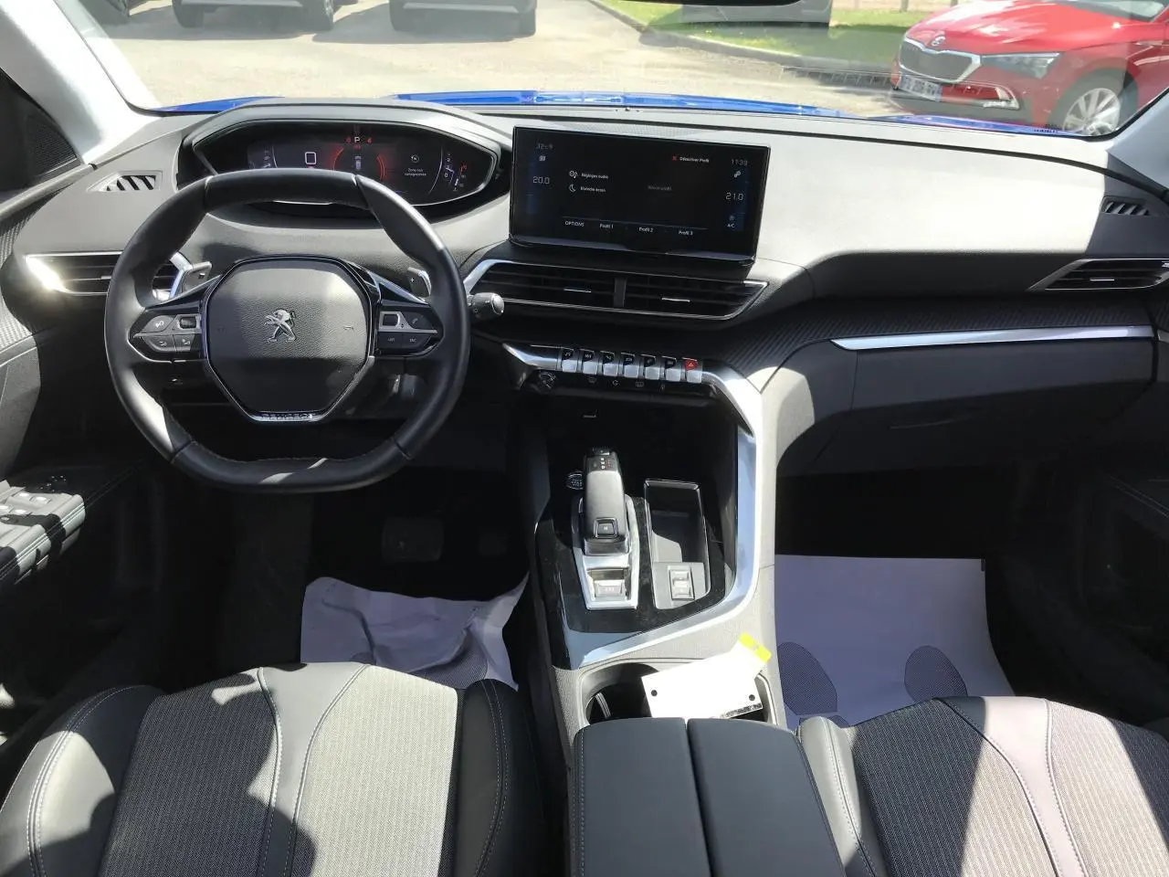 Vue intérieure avant du Peugeot 3008 Bleu Iron 2022, volant compact, écran tactile 10 pouces et console centrale moderne.