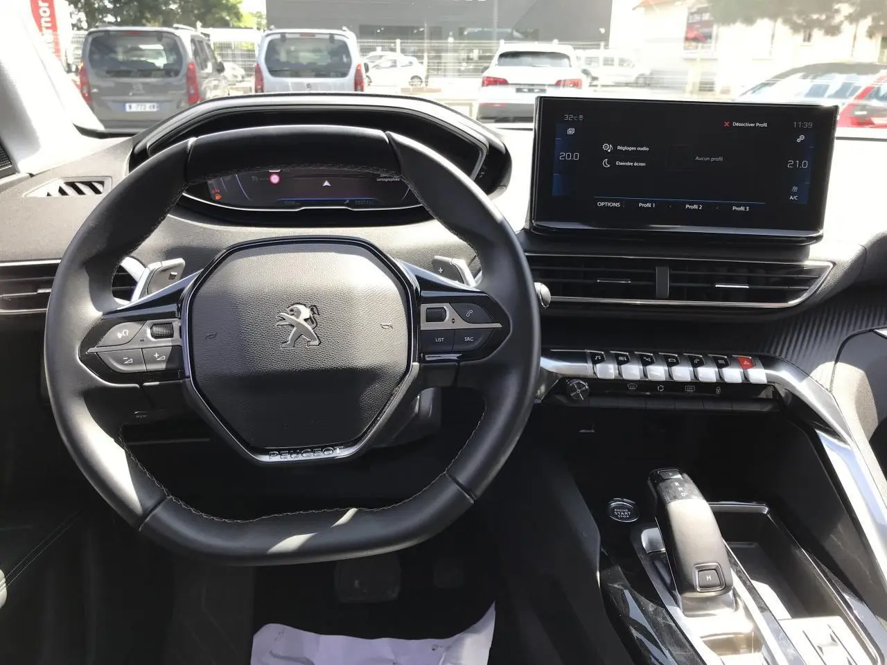 Vue intérieure du poste de conduite du Peugeot 3008 2022, volant compact cuir et écran tactile 10 pouces central.