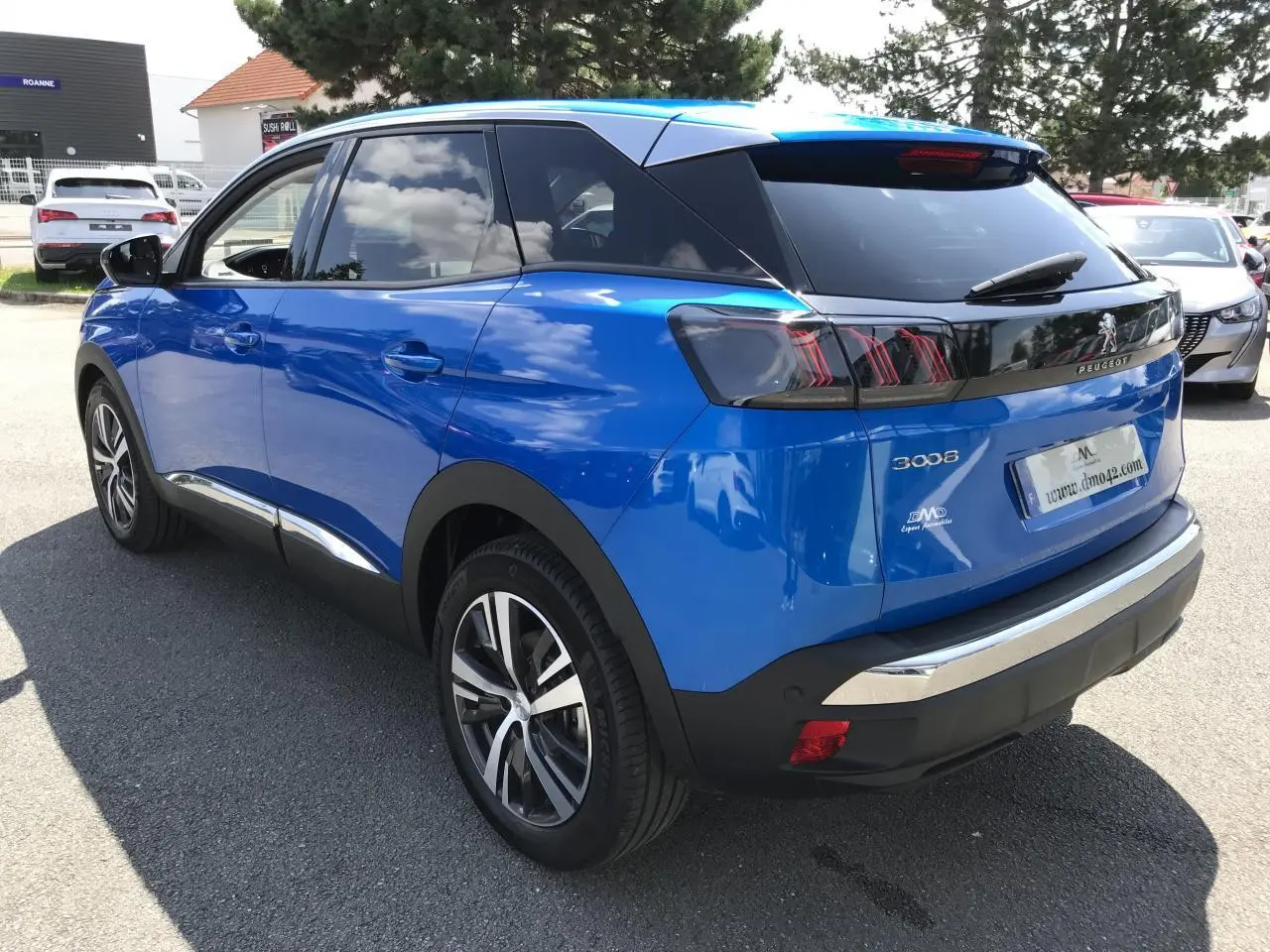 Vue 3/4 arrière droite d’un Peugeot 3008 bleu Iron avec jantes alliage bi-ton et vitres arrière surteintées.